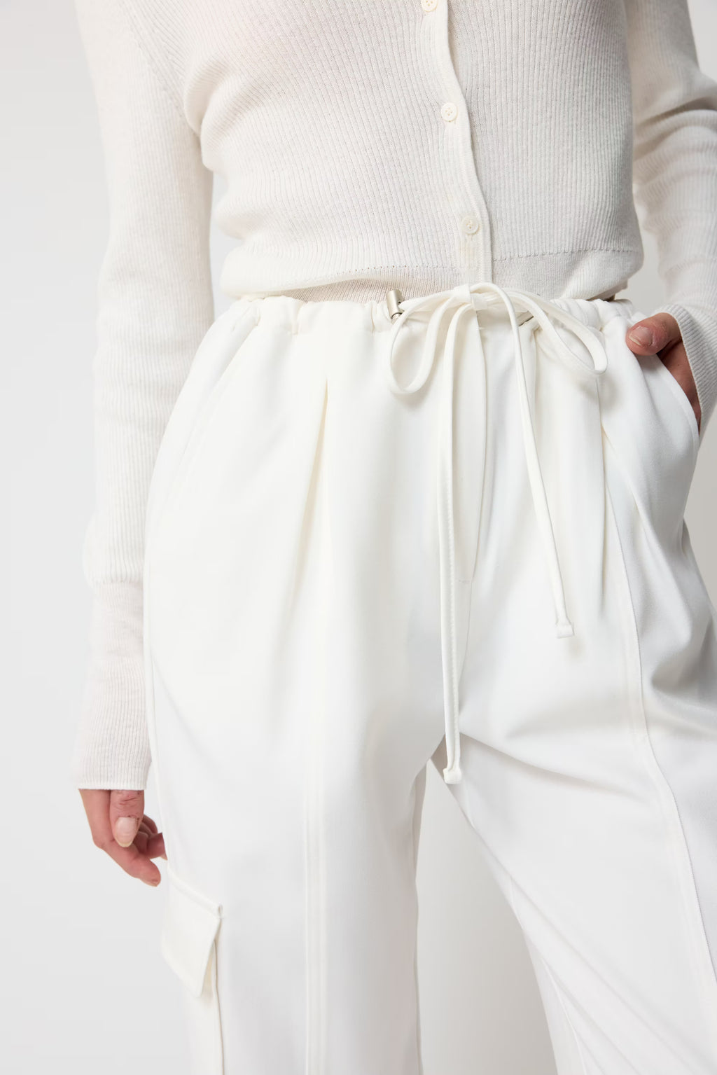 White pants with drawstring waist worn by a person on a white background
