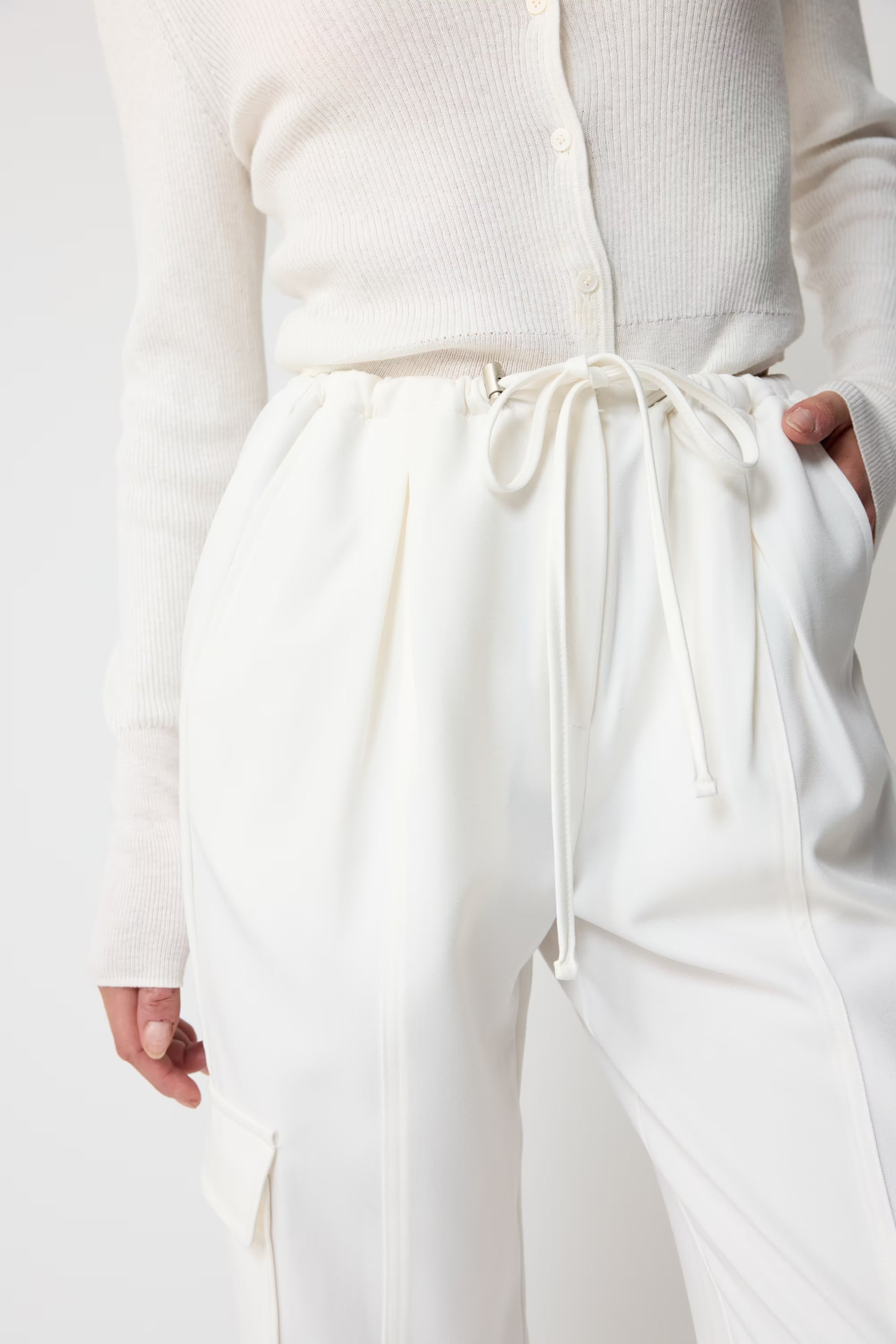 White pants with drawstring waist worn by a person on a white background