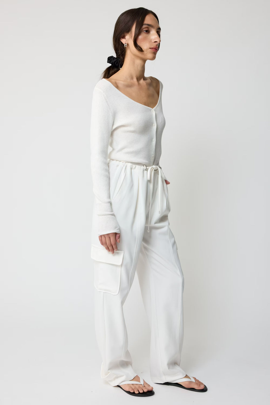 Woman wearing a white outfit on a plain background