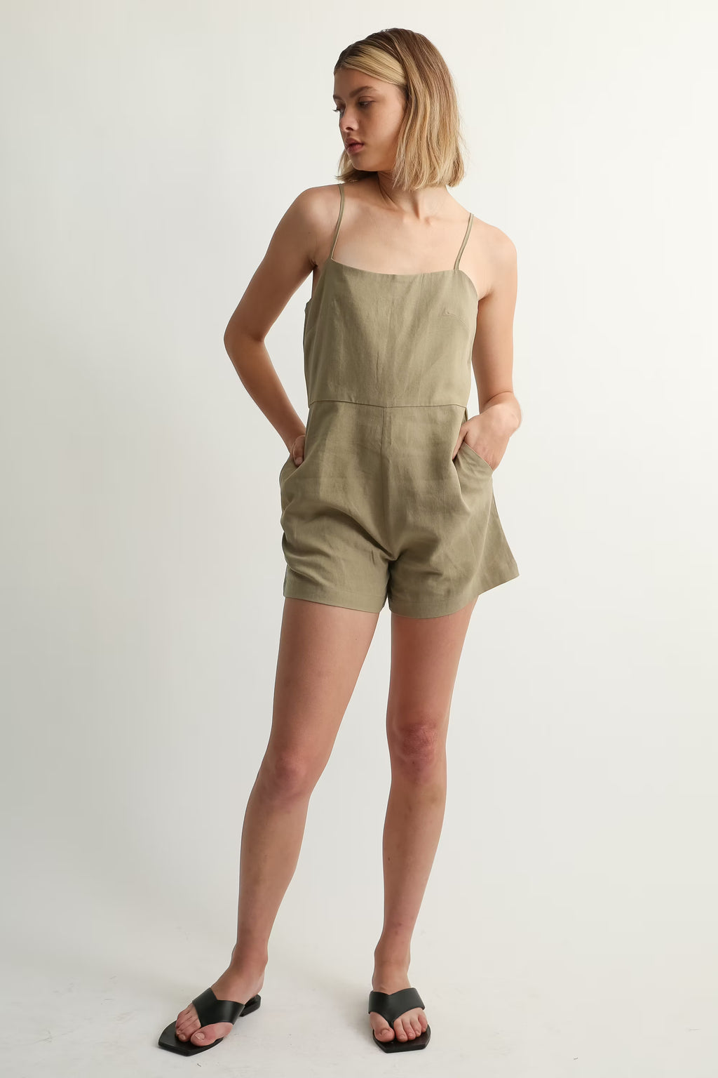 Woman wearing a green jumpsuit on a white background