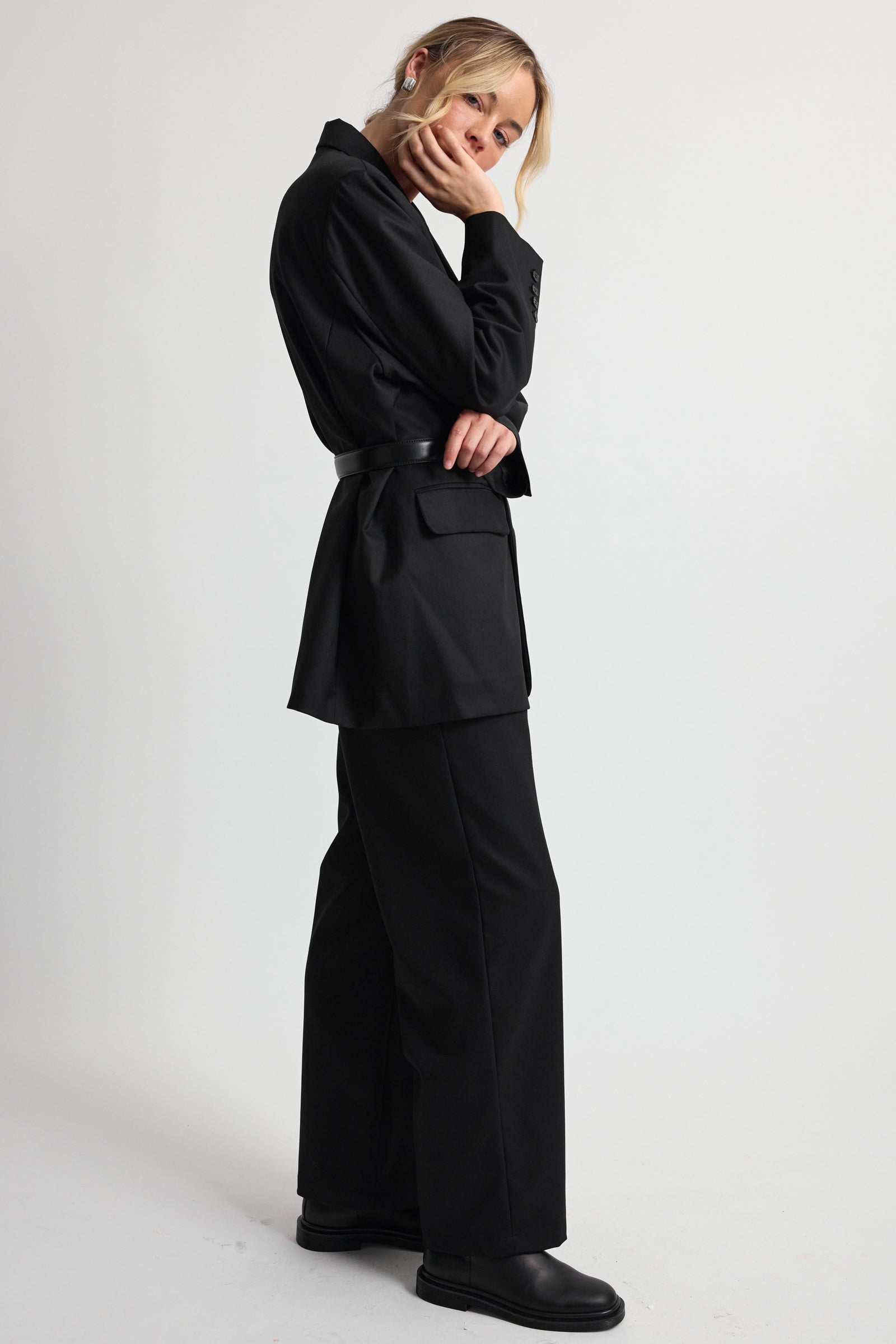 Woman wearing a black suit on a white background