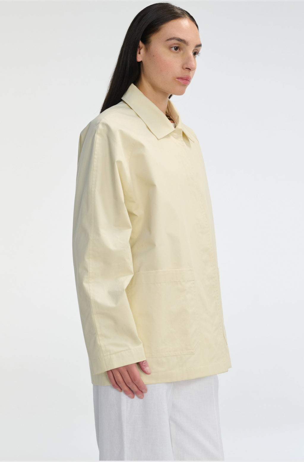 Woman wearing a light yellow shirt on a white background
