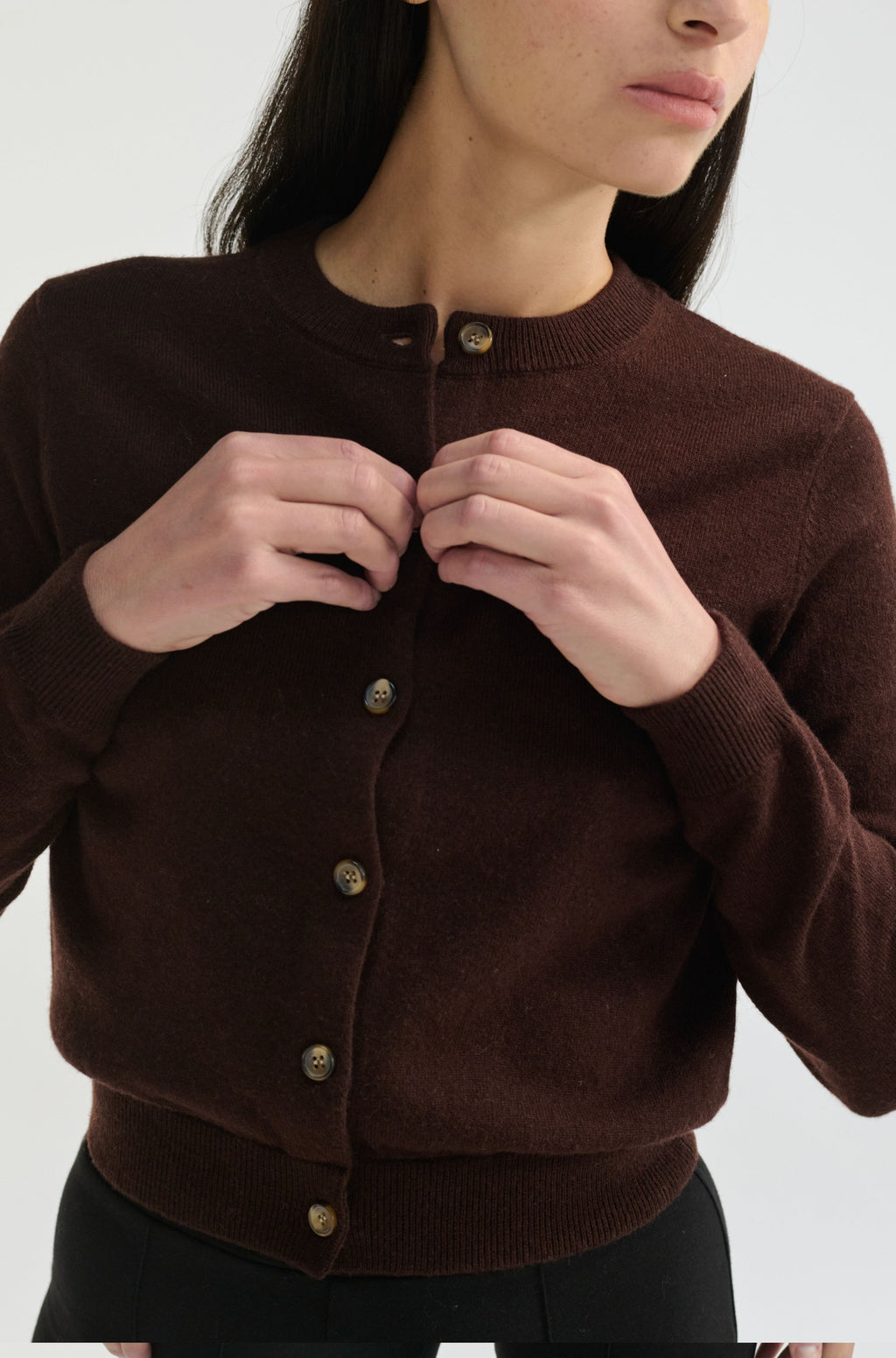 Brown cardigan worn by a person on a white background