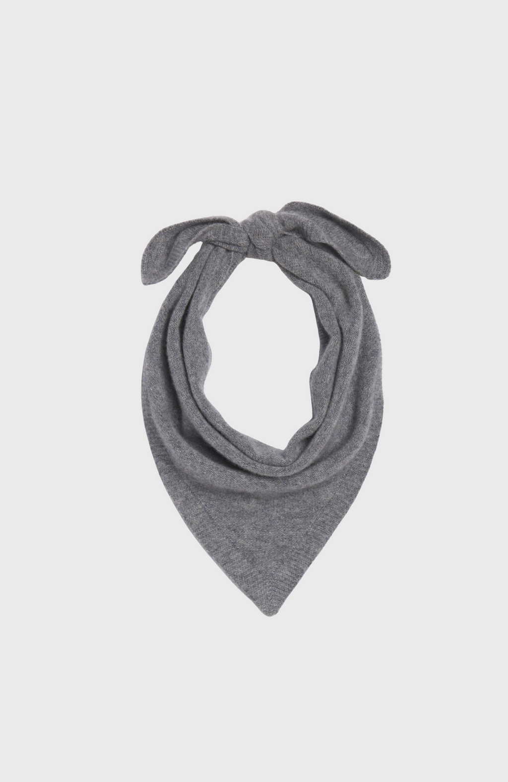 Woman wearing a grey scarf over a black outfit on a light grey background