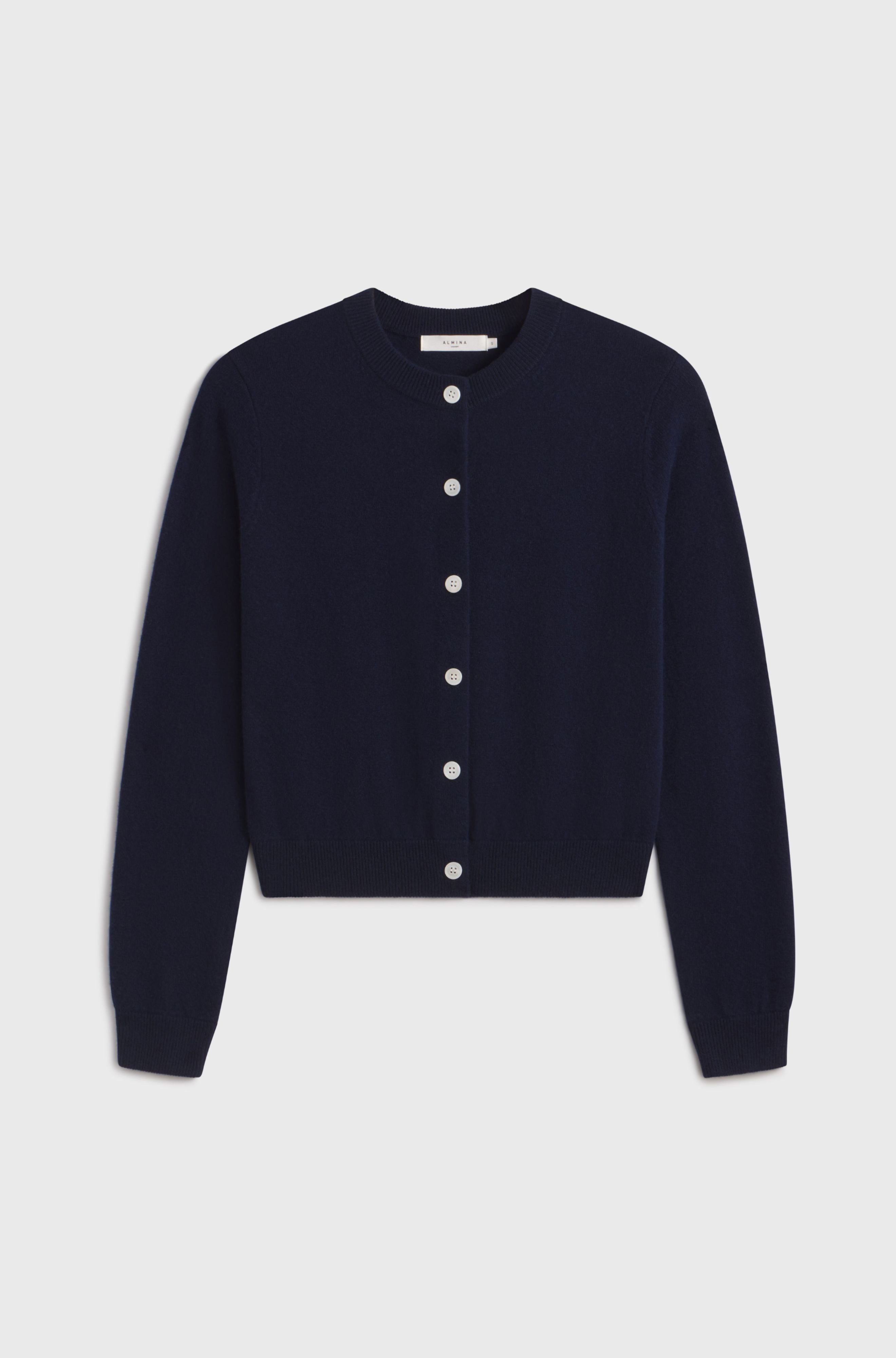 Navy blue cardigan with white buttons on a light gray background
