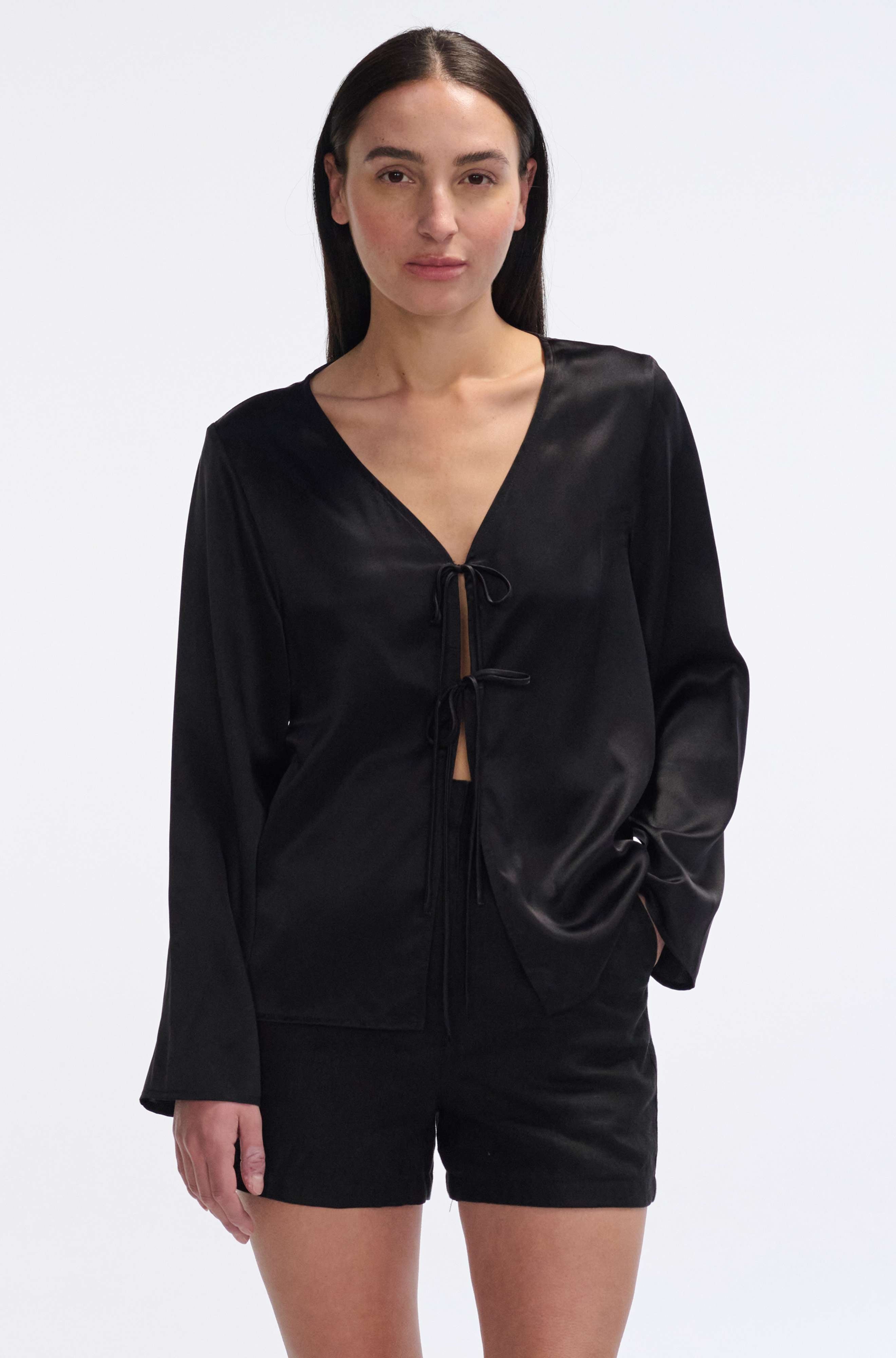 Woman wearing a black silk shirt on a white background