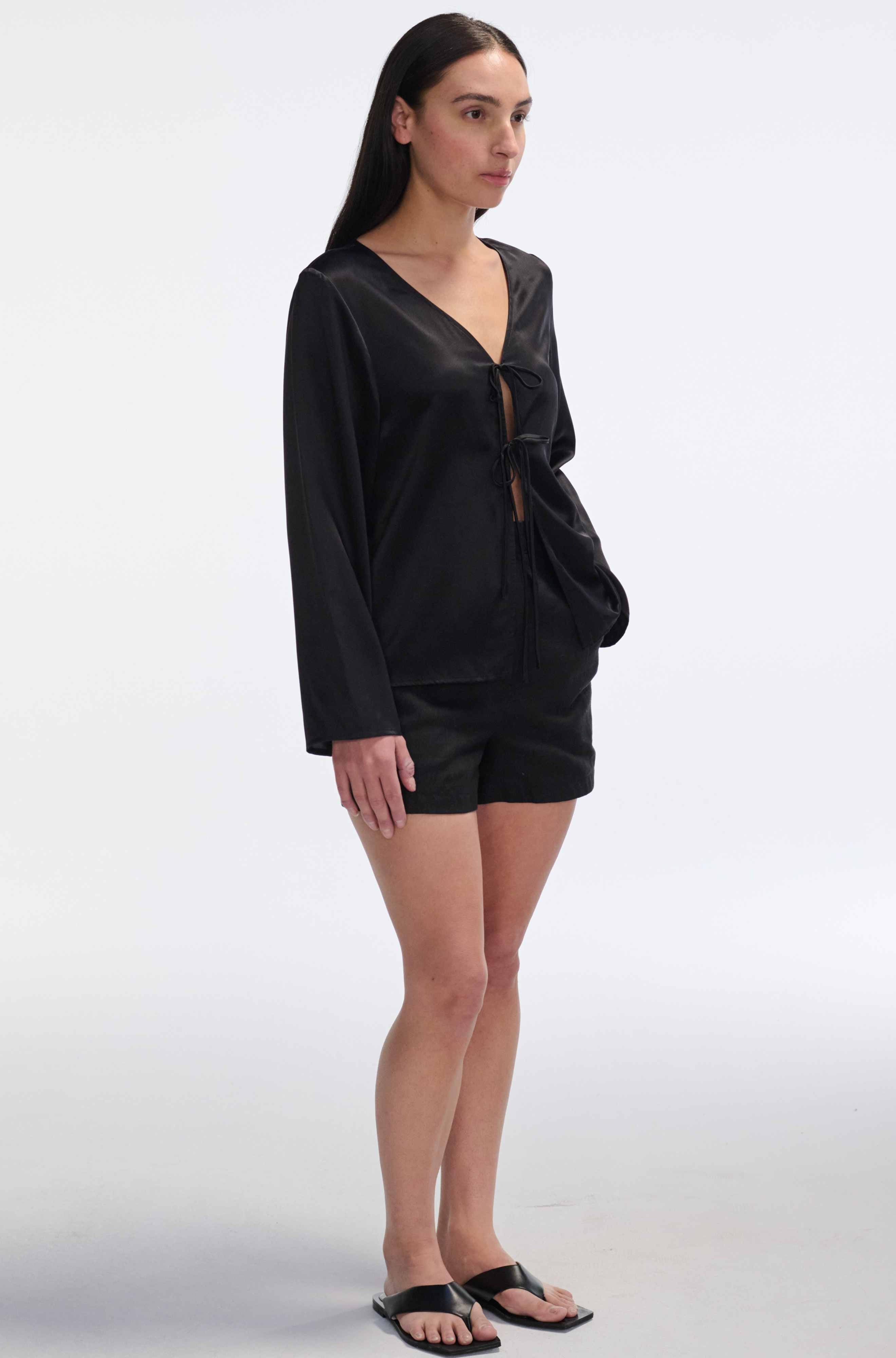Woman wearing a black silk shirt on a white background