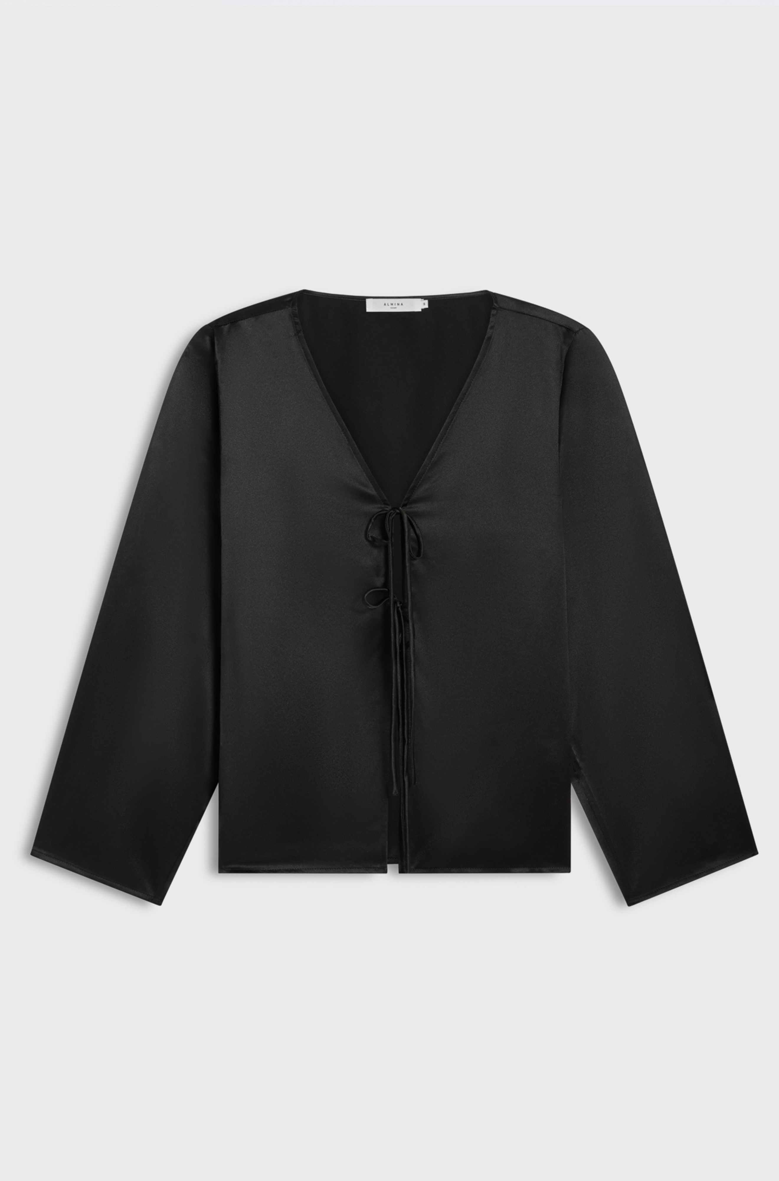 Black silk blouse with a V-neck and long sleeves on a light gray background