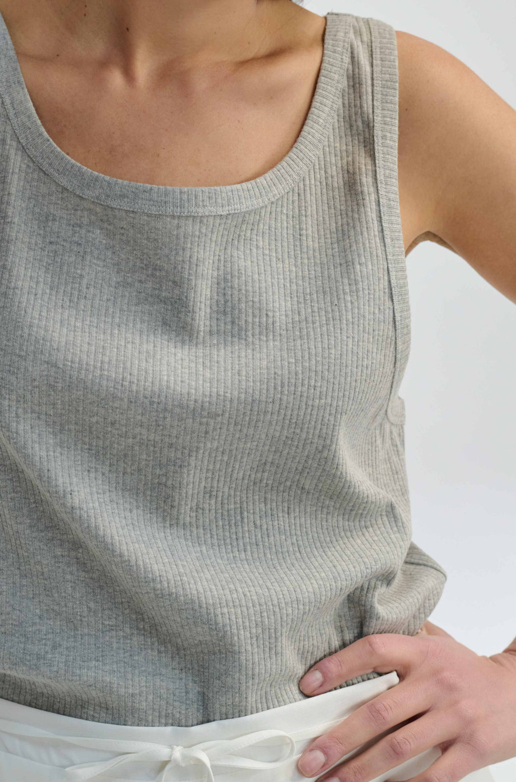 Gray tank top worn by a person on a white background