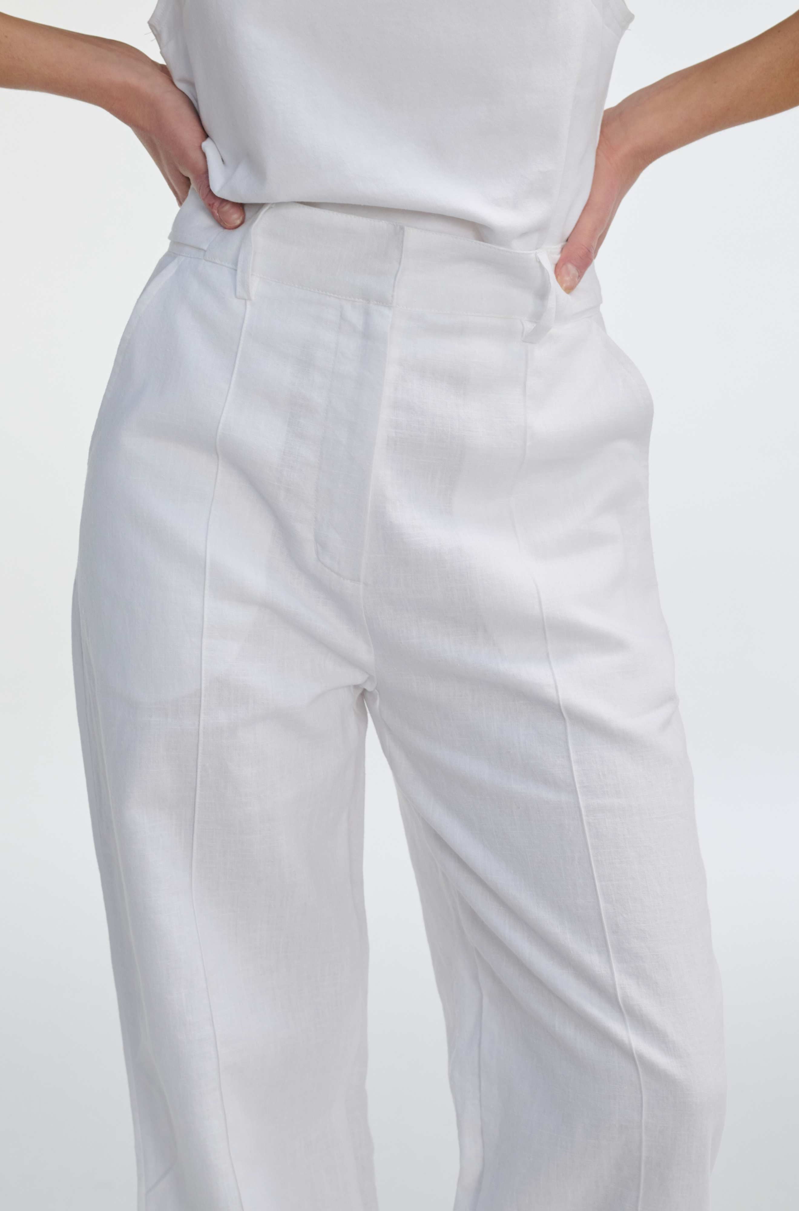 White pants worn by a person on a light gray background