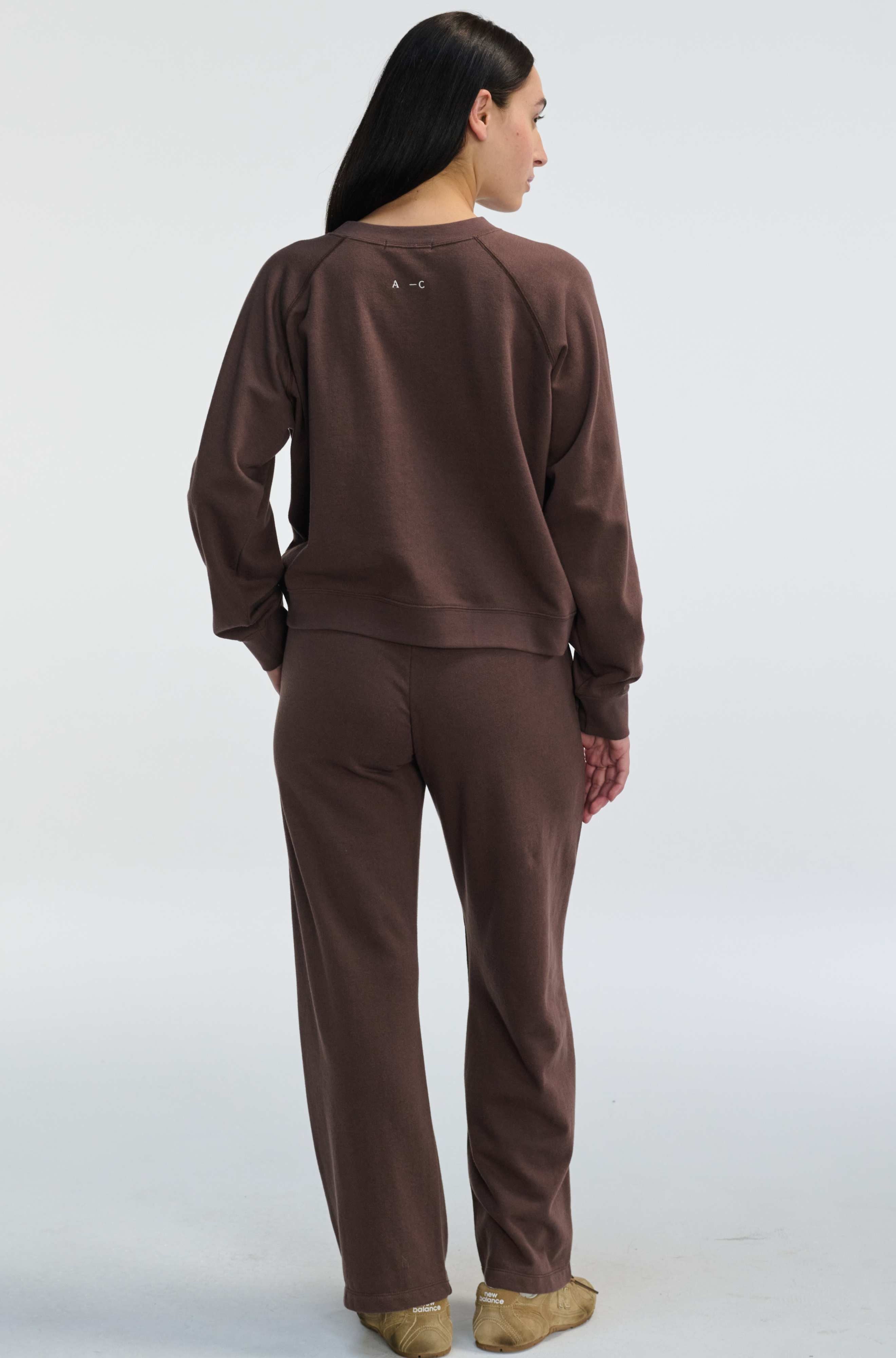 Person wearing a brown tracksuit on a white background
