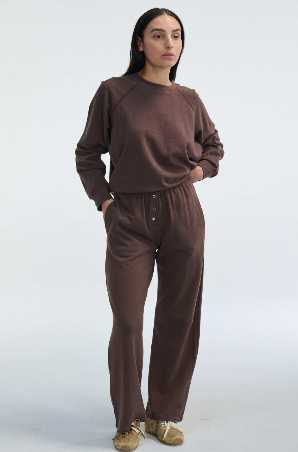 Woman wearing a brown outfit on a white background