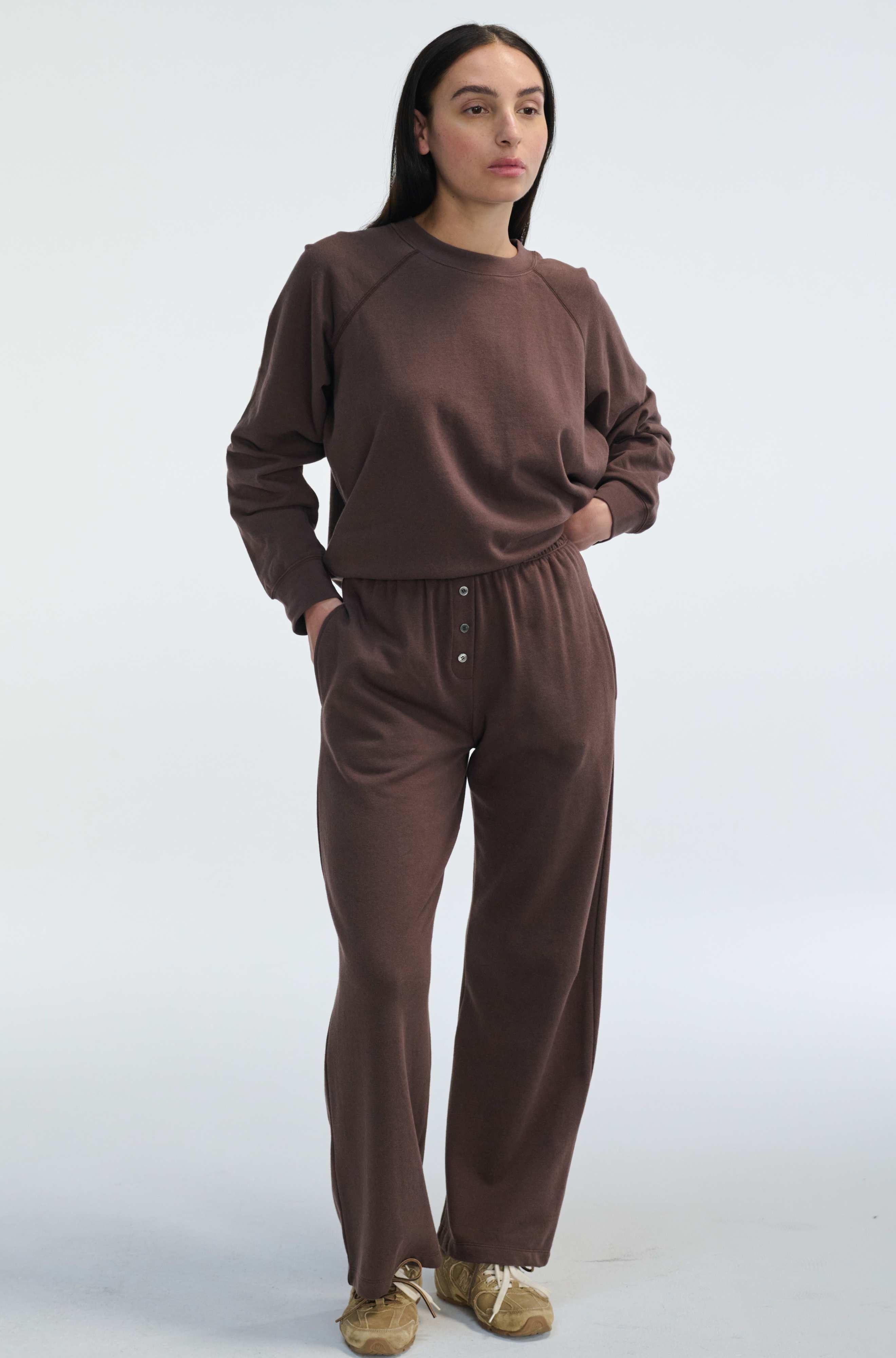 Woman wearing a brown outfit on a white background