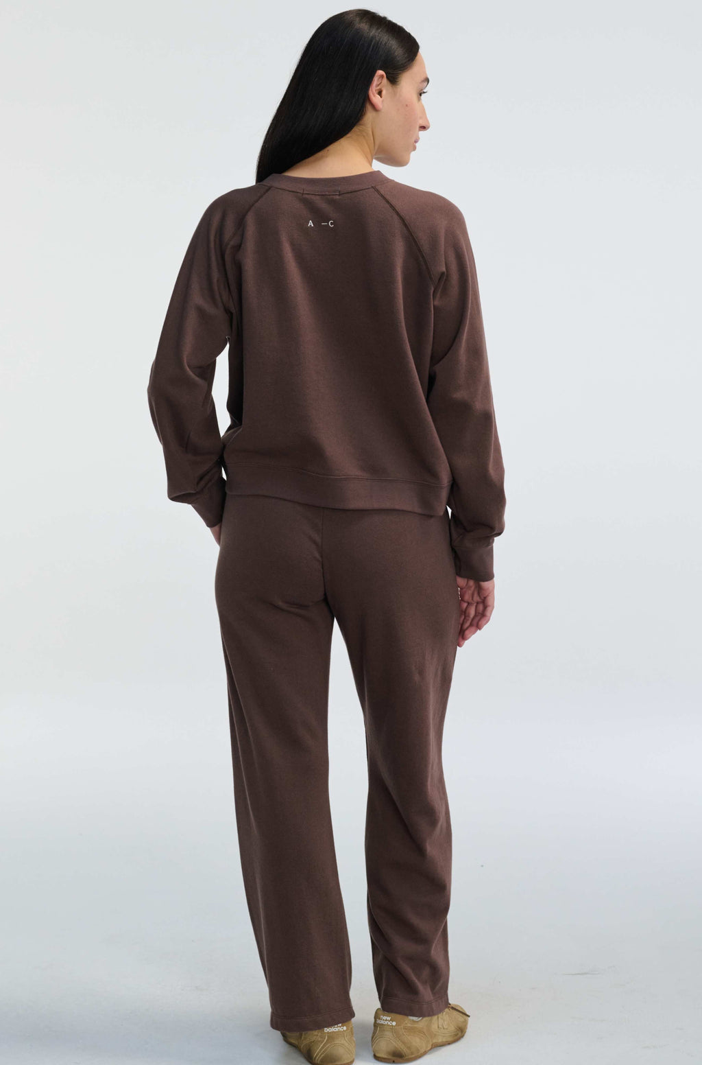 Person wearing a brown tracksuit on a white background