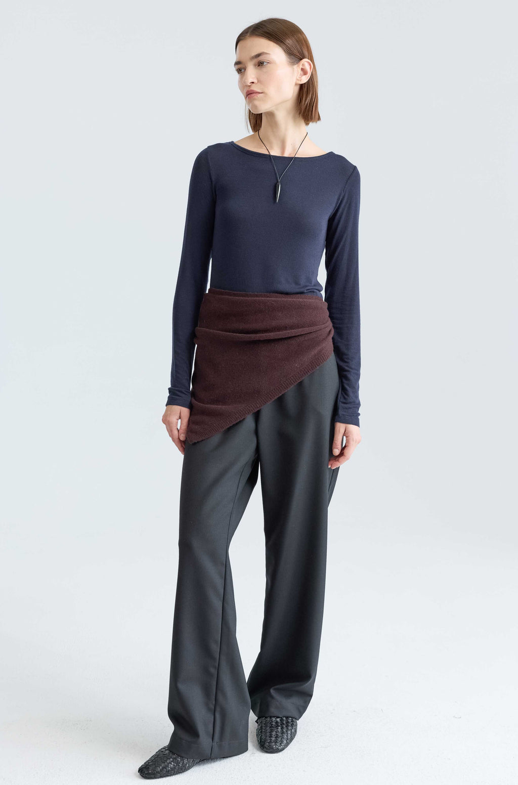 Woman wearing a long sleep dark blue tee and a brown scarf around her waist