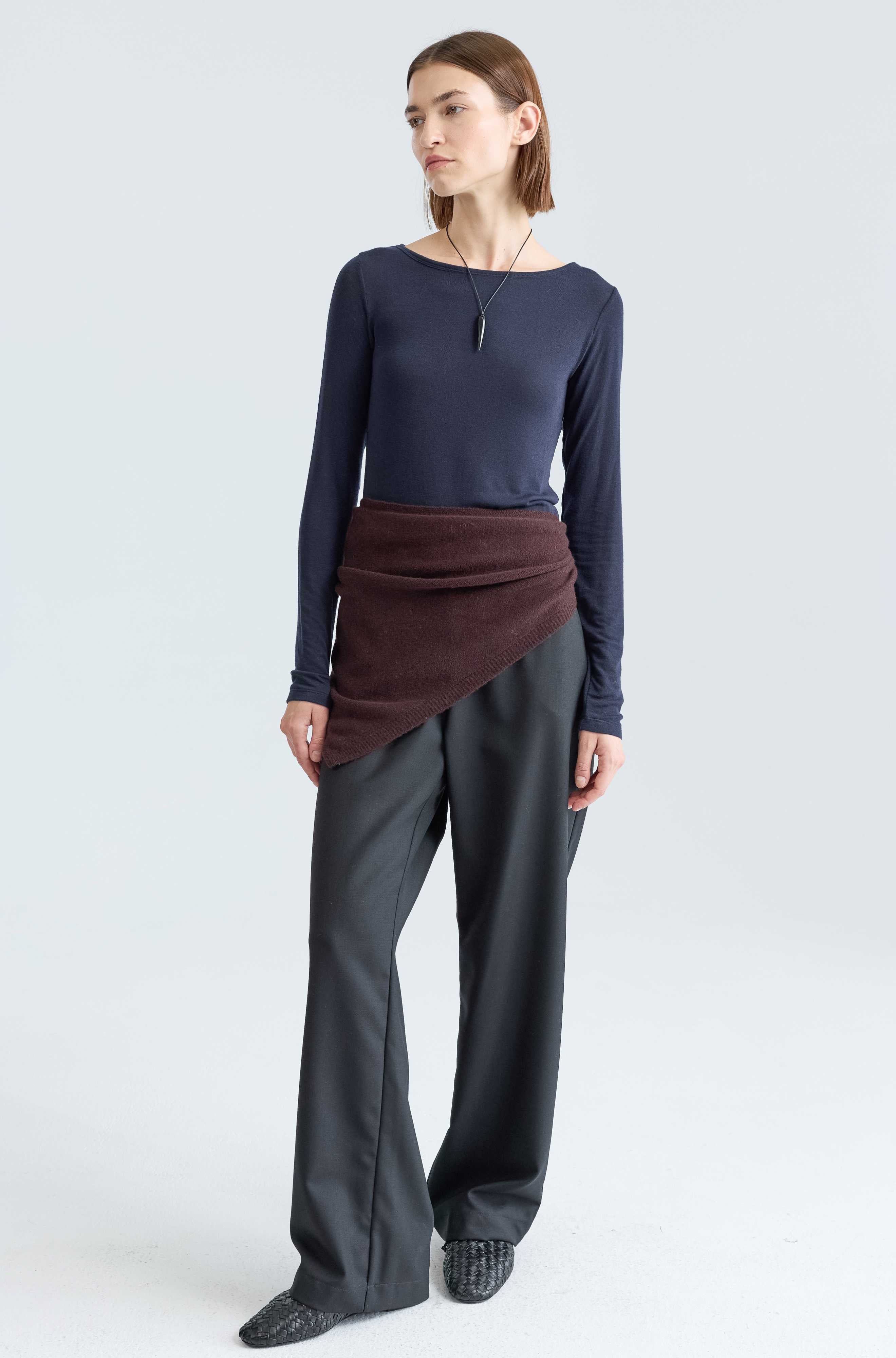 Woman wearing a long sleep dark blue tee and a brown scarf around her waist