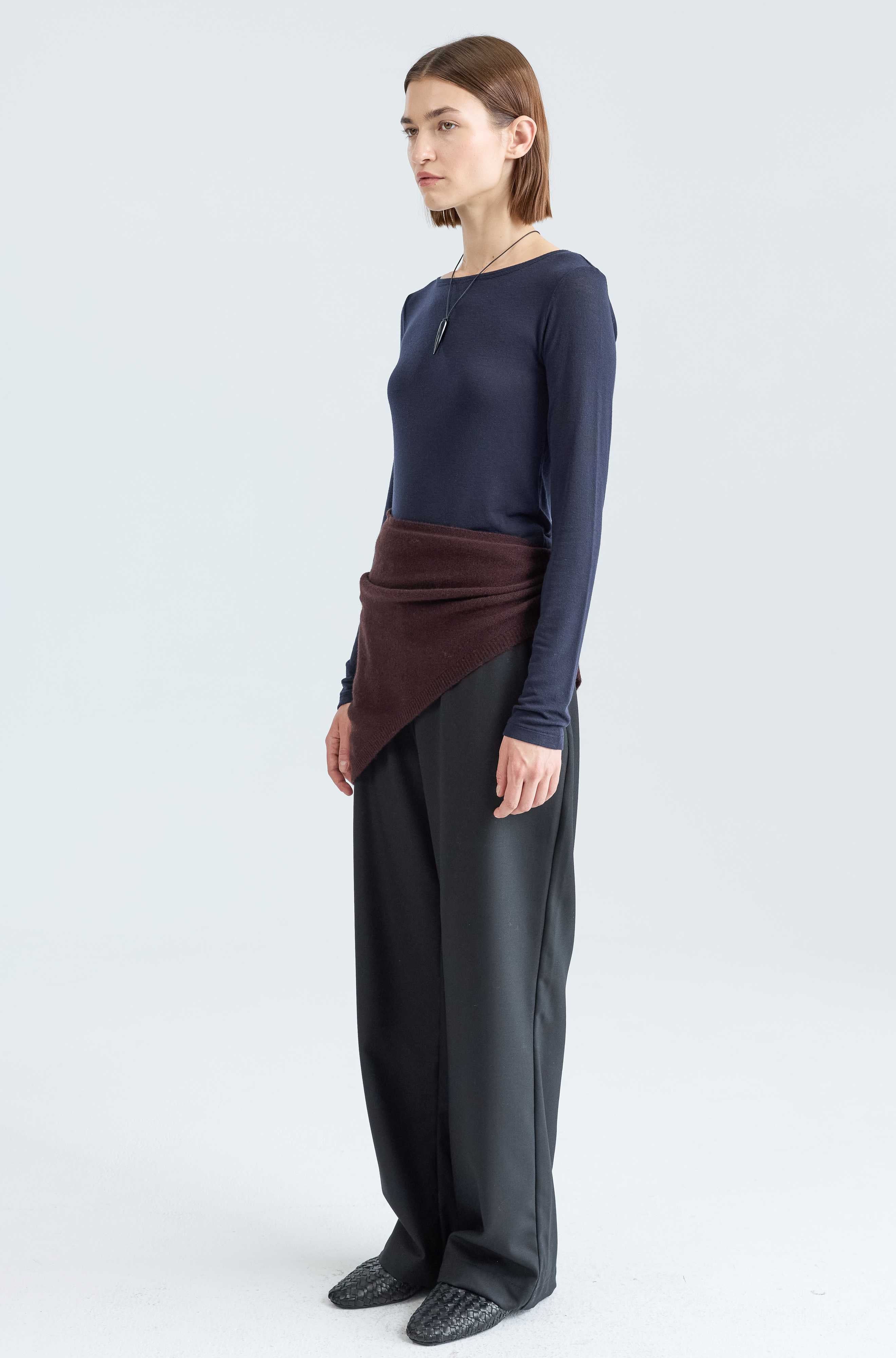 Woman wearing a long sleep dark blue tee and a brown scarf around her waist