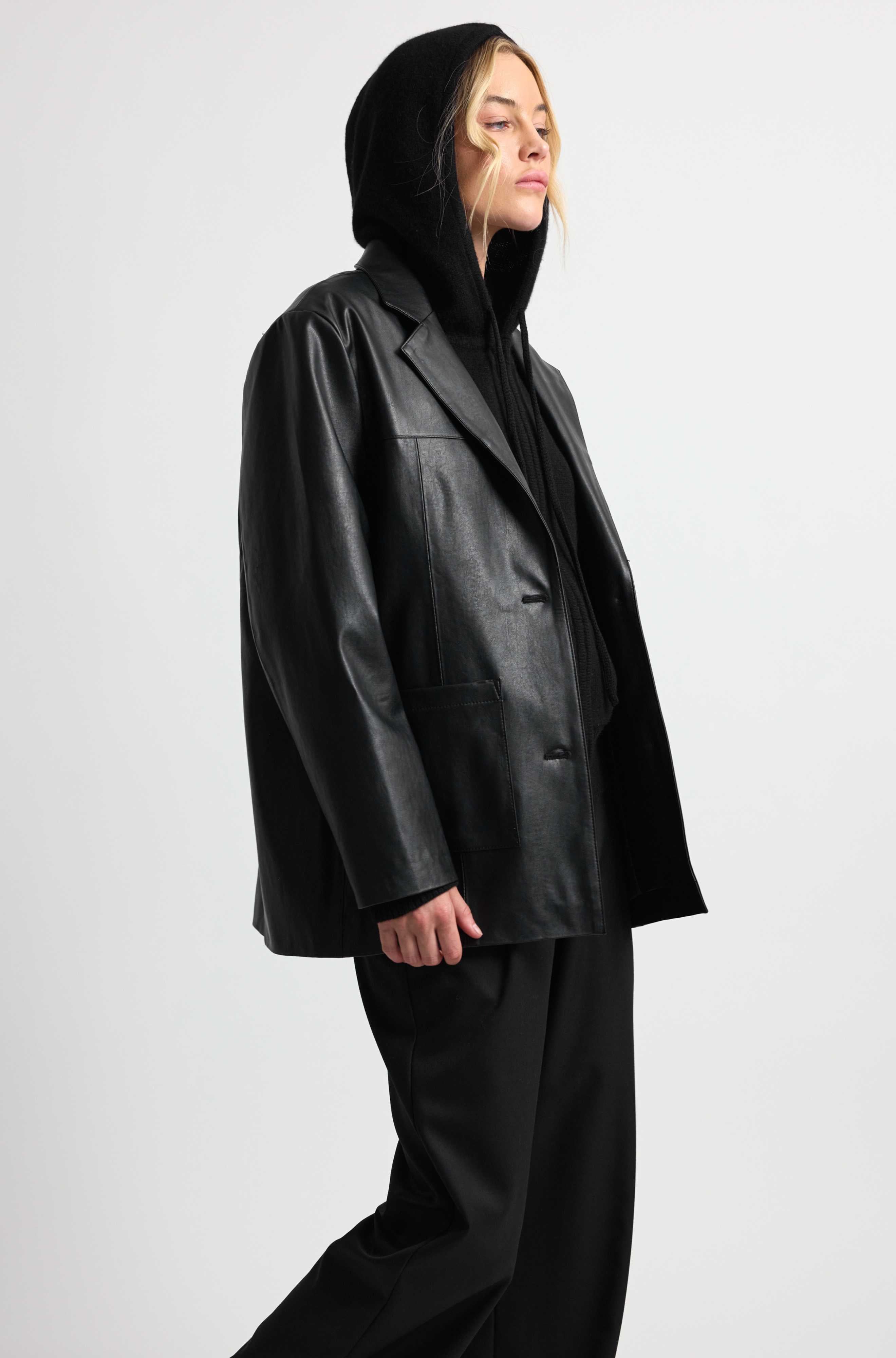 Person wearing a black leather outfit on a white background