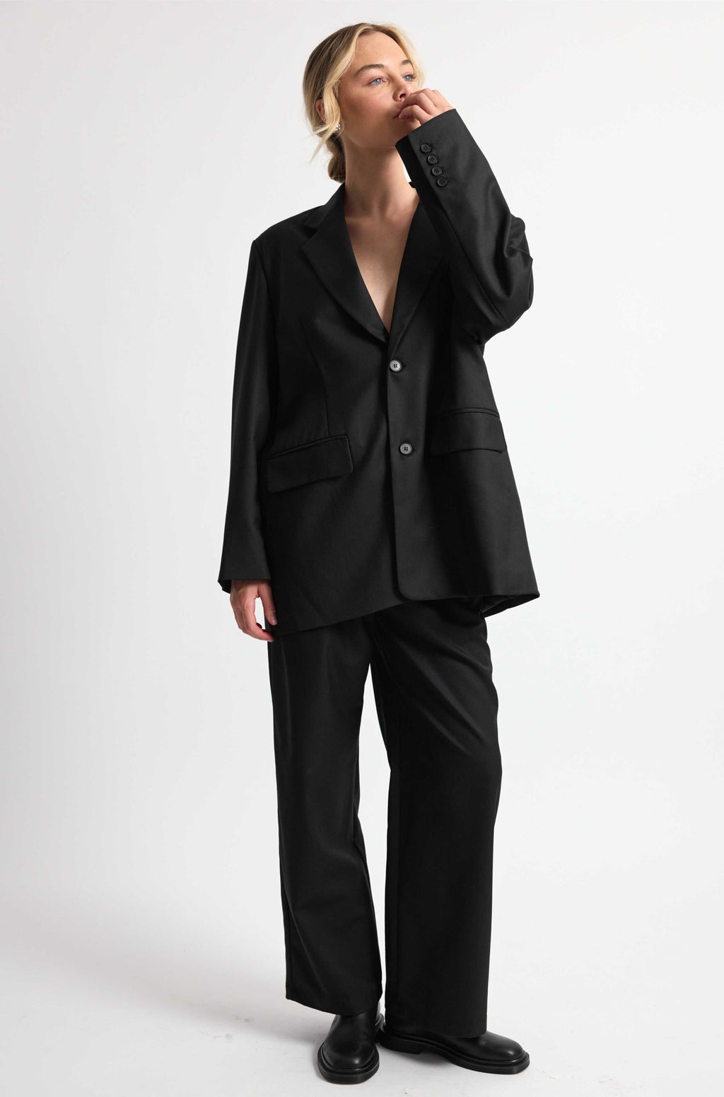 Person wearing a black suit on a white background