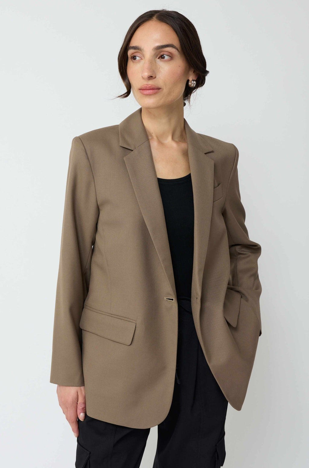 Woman wearing a brown blazer against a white background