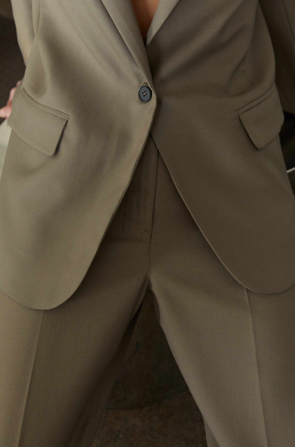 Close-up of a person wearing a beige suit with a blurred background