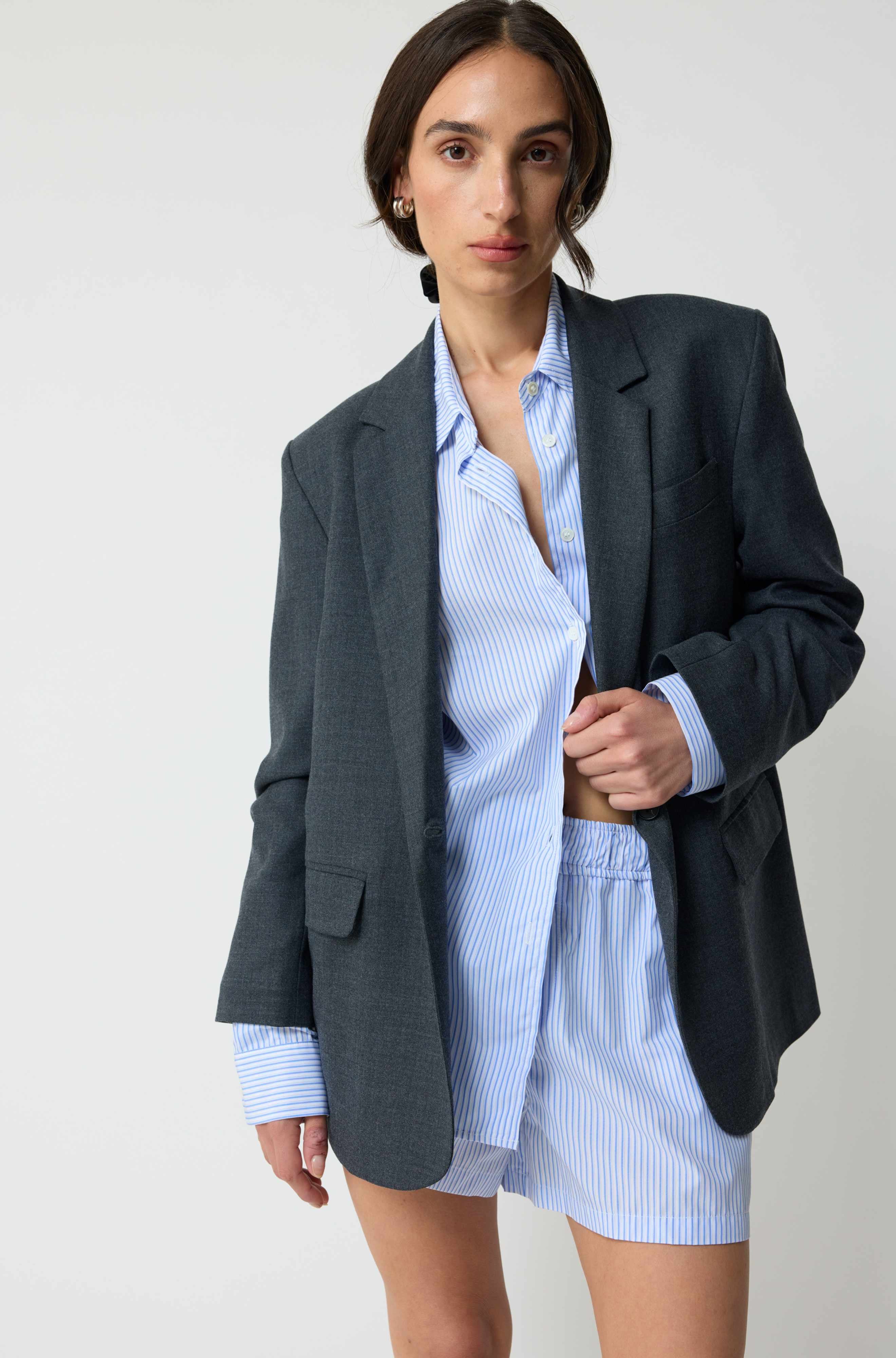 Woman wearing a grey blazer over a striped set