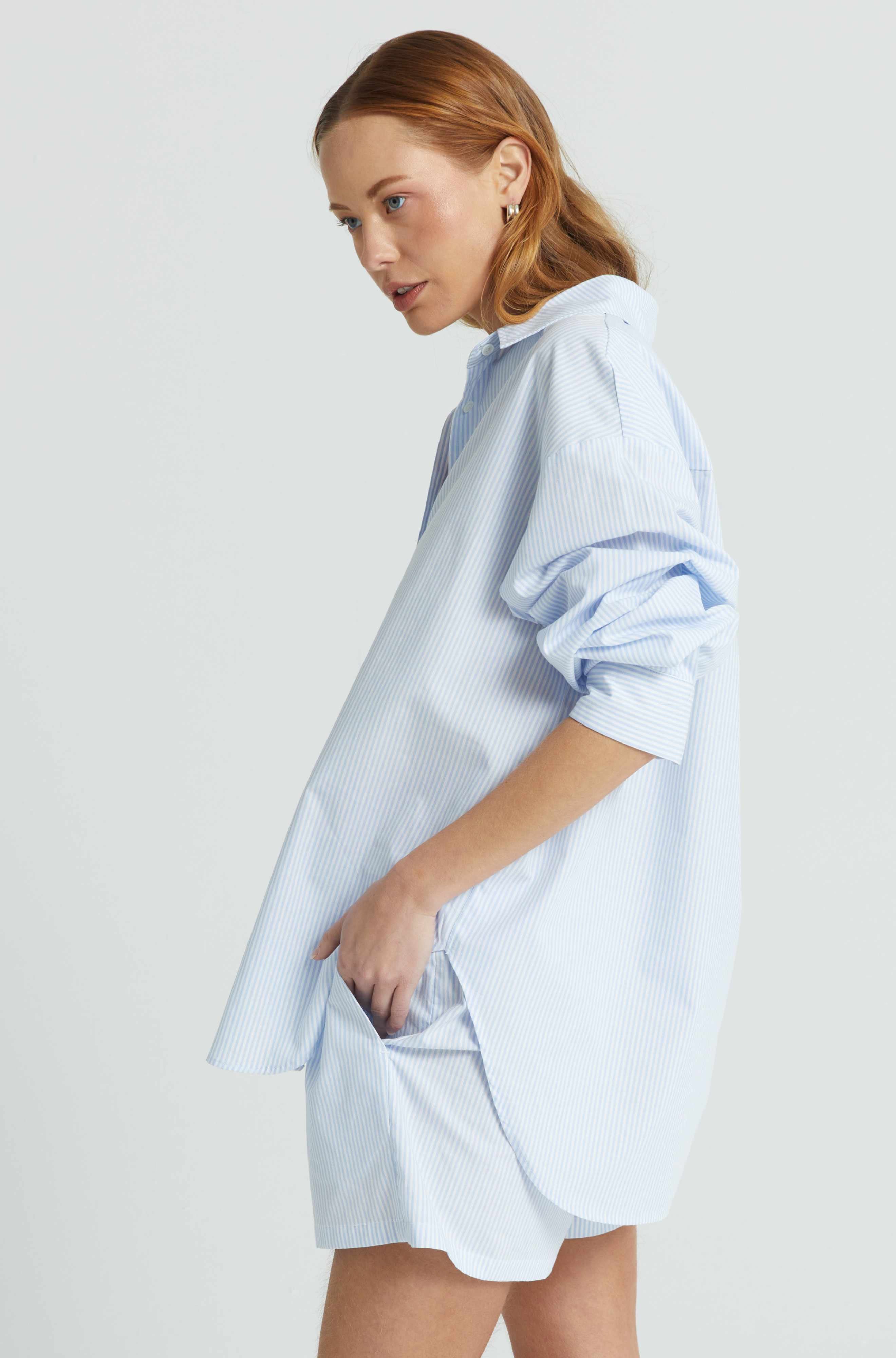 Woman wearing a light blue checkered dress against a white background