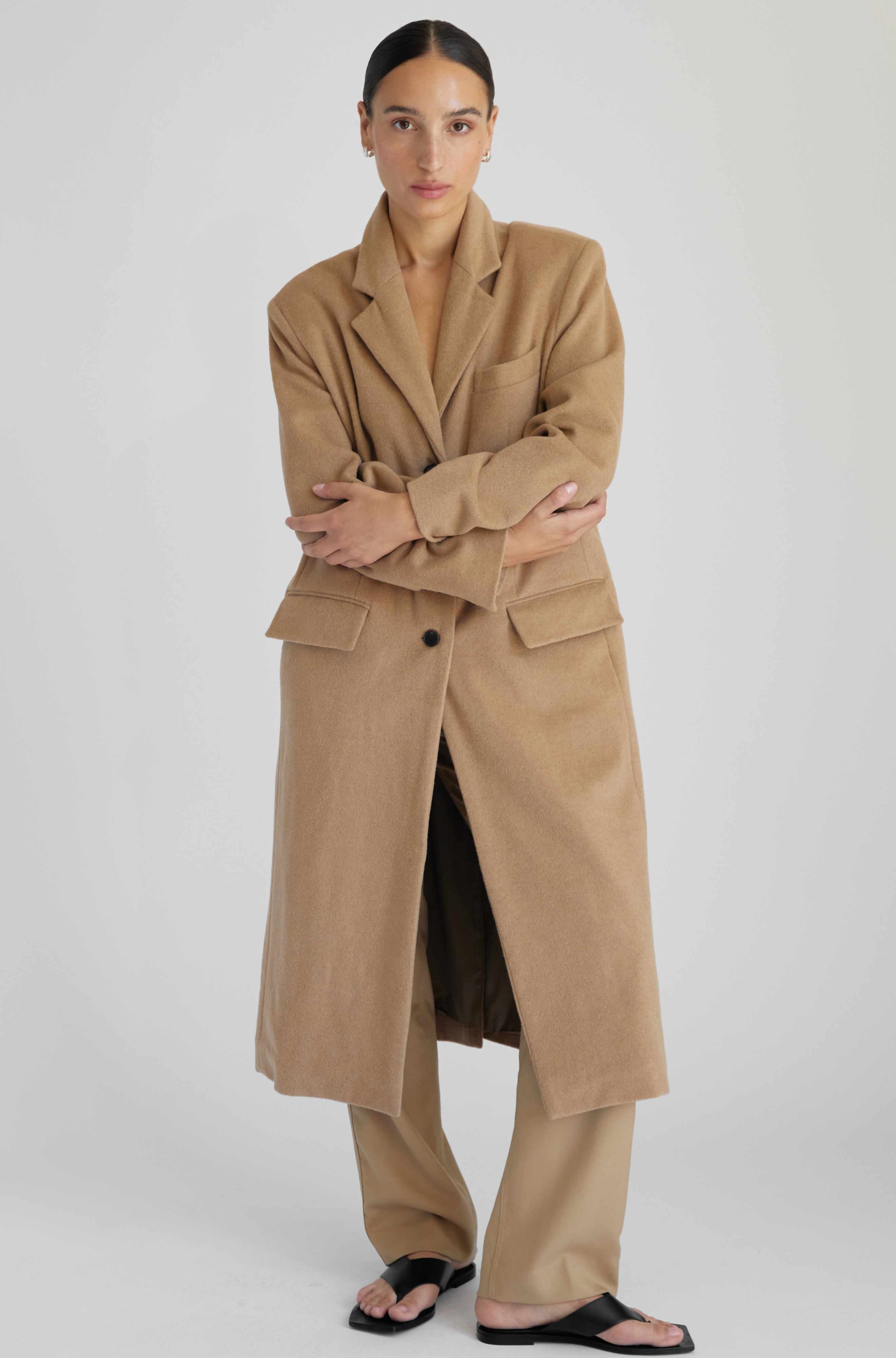 Woman wearing a beige trench coat on a white background