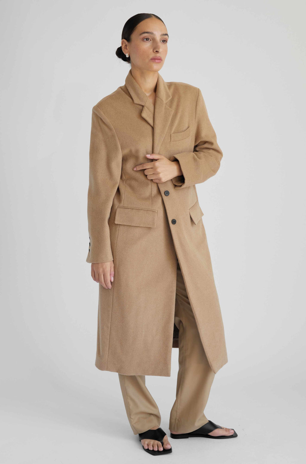 Woman wearing a beige trench coat on a white background