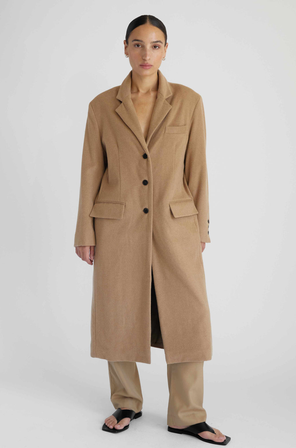 Woman wearing a beige trench coat on a white background