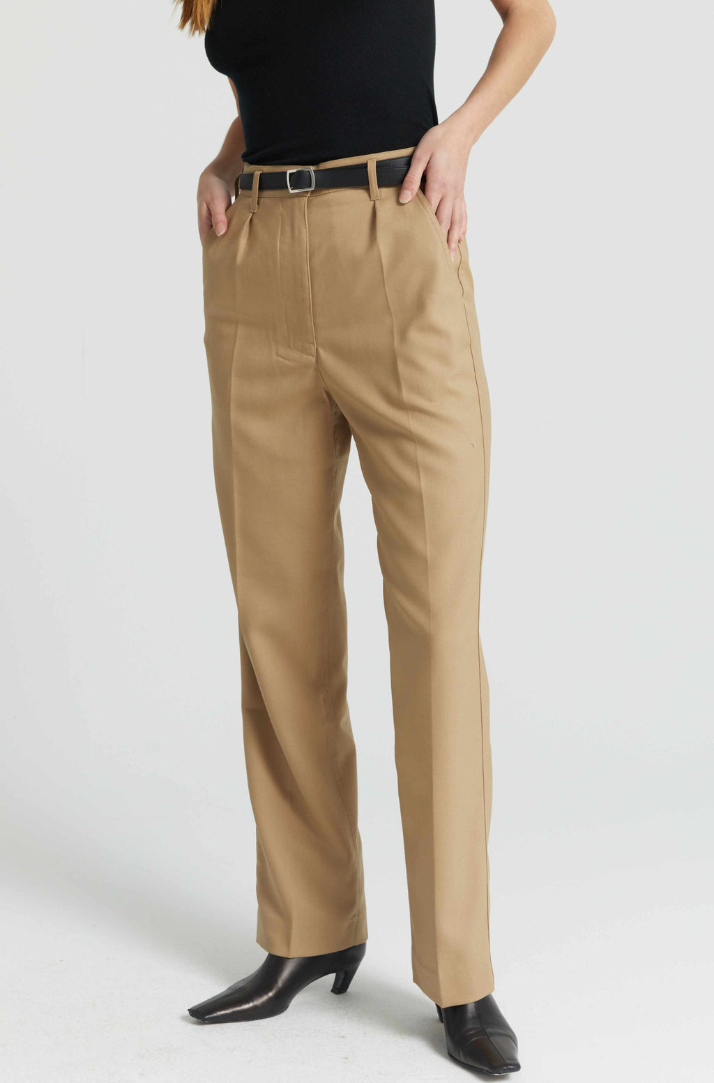 Beige pants worn by a person on a white background