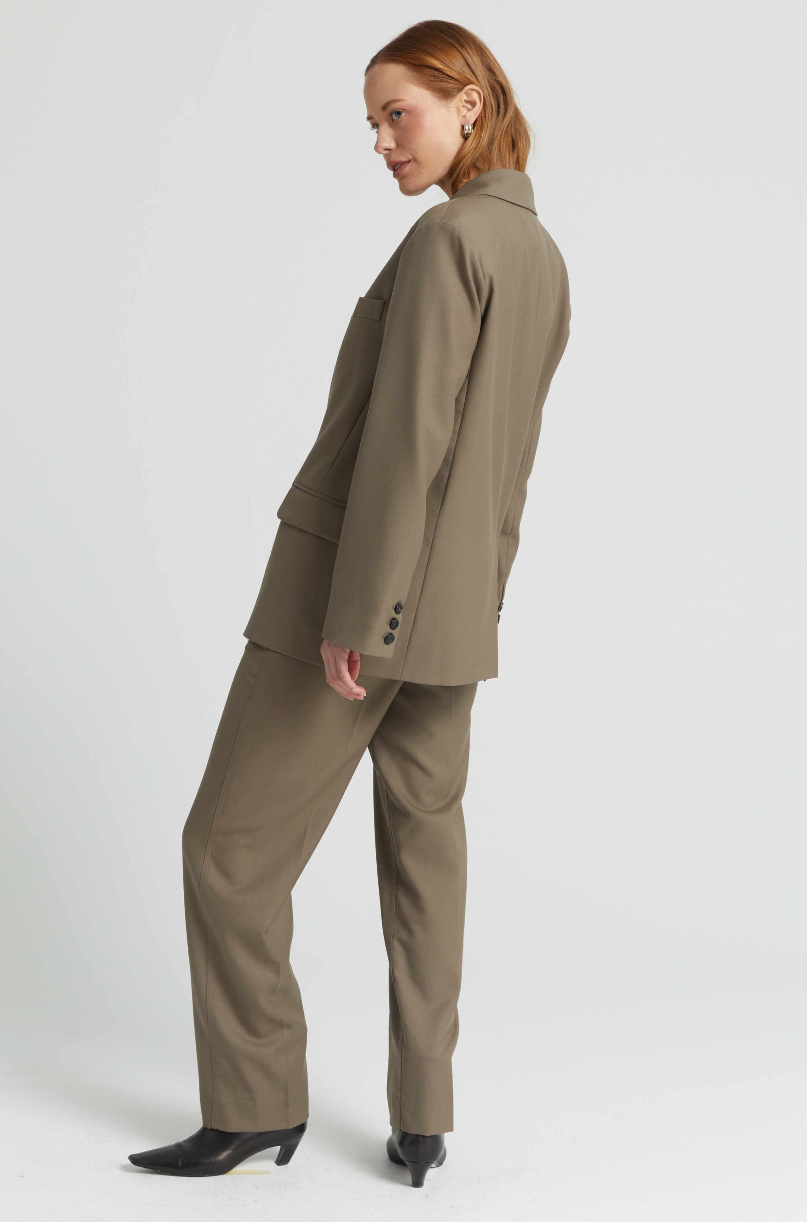 Woman wearing a beige suit on a white background