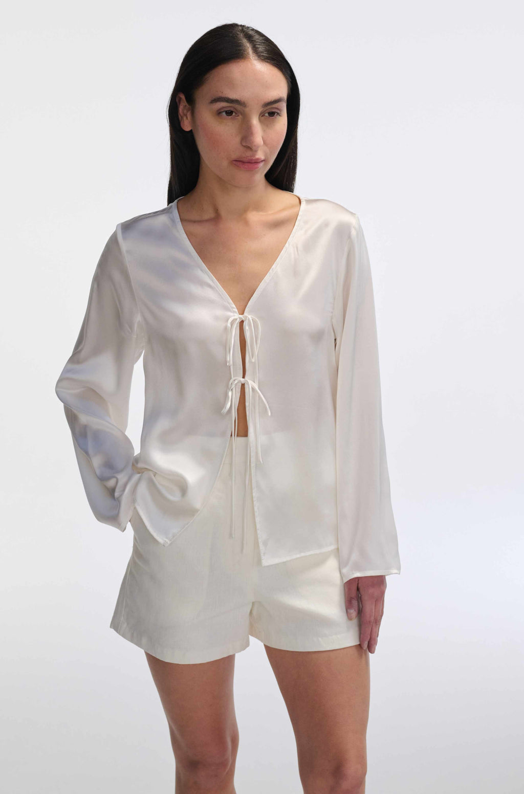 Woman wearing a white outfit with a plain background