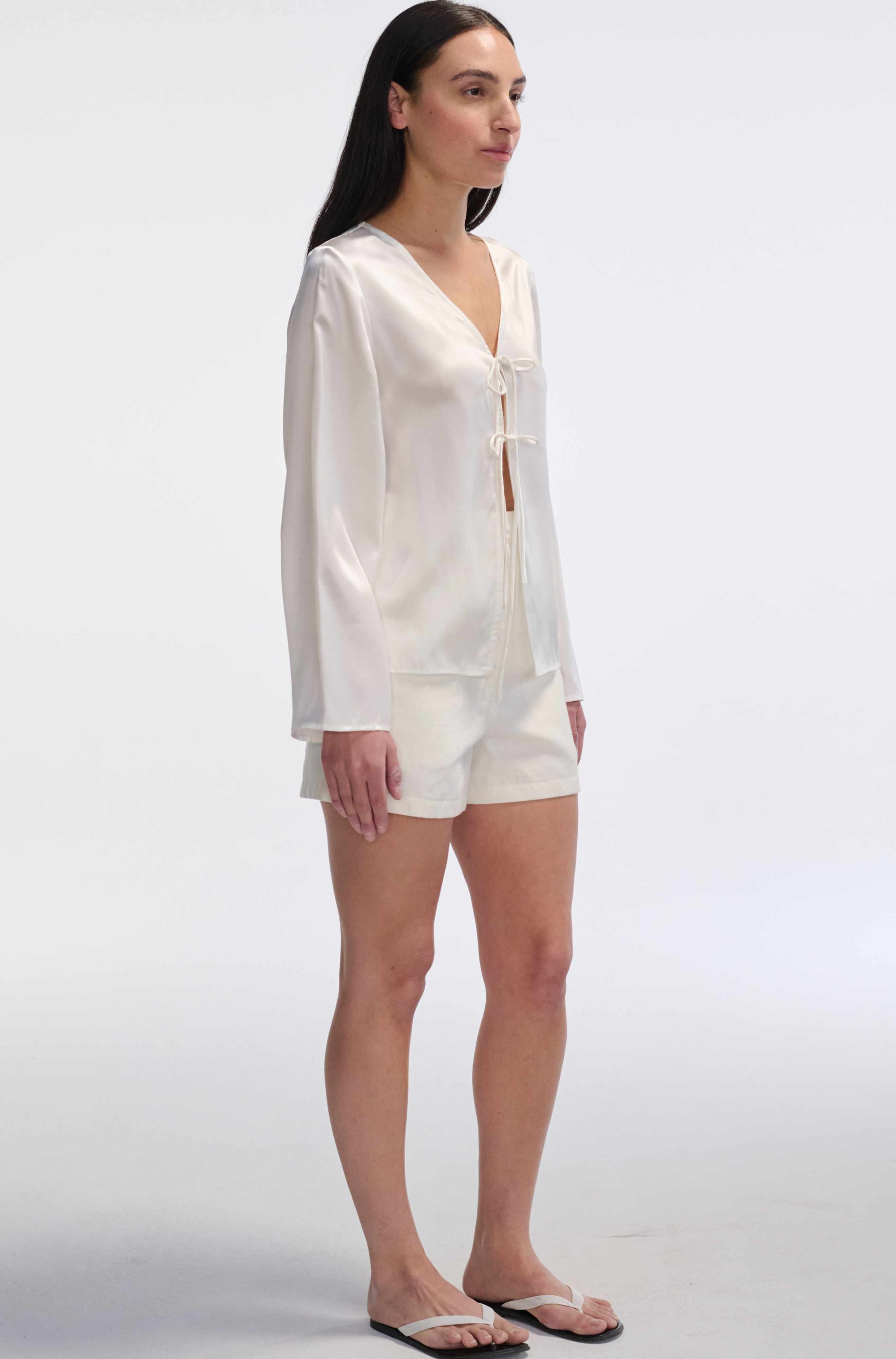 Woman wearing a white outfit on a plain background