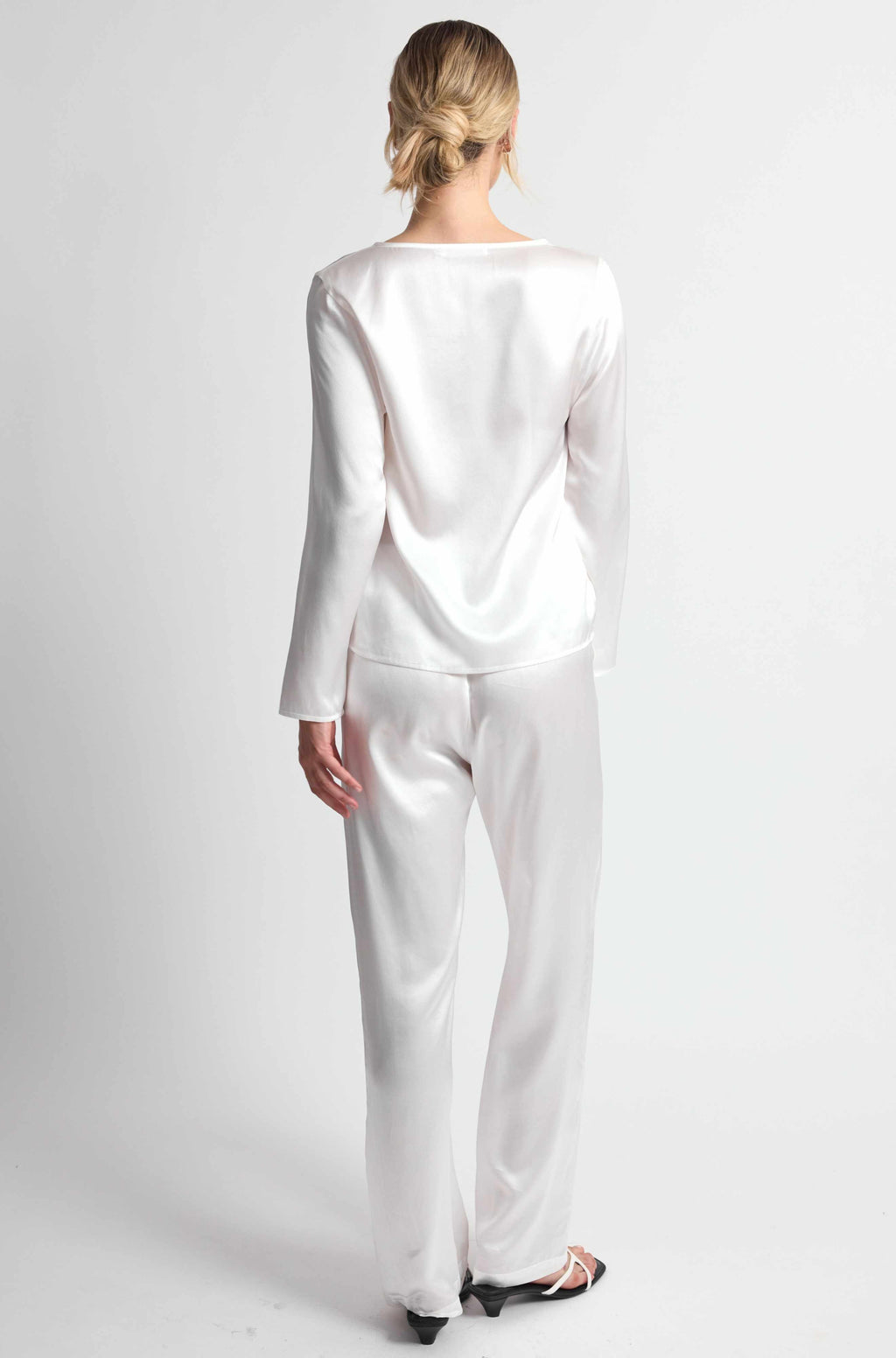 Person wearing a white outfit on a plain background