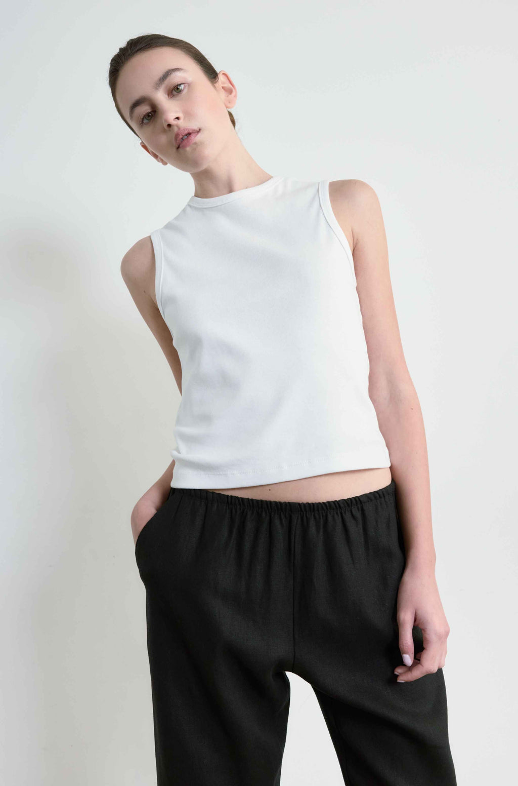 Woman wearing a white round neck tank 