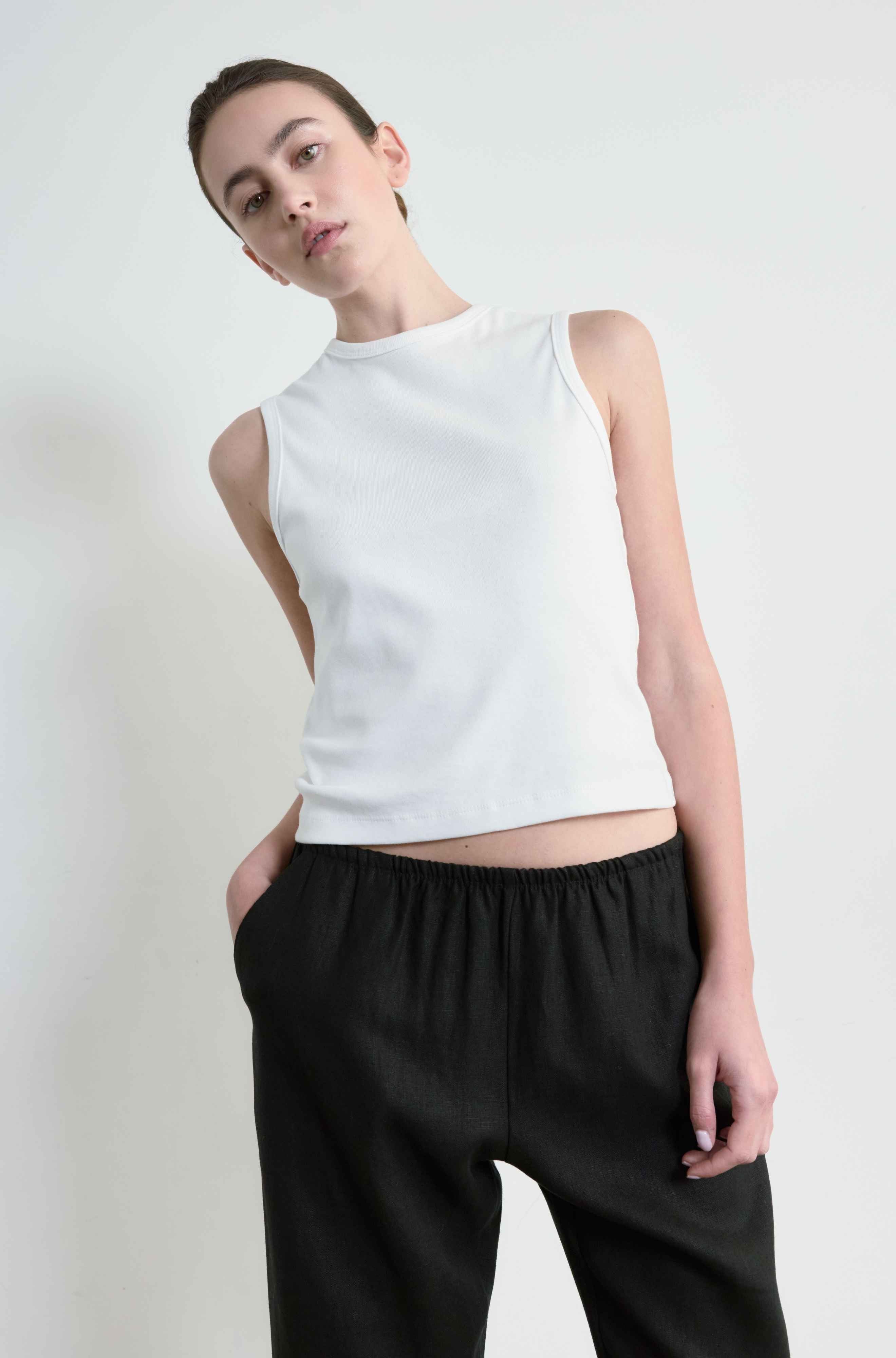 Woman wearing a white round neck tank 