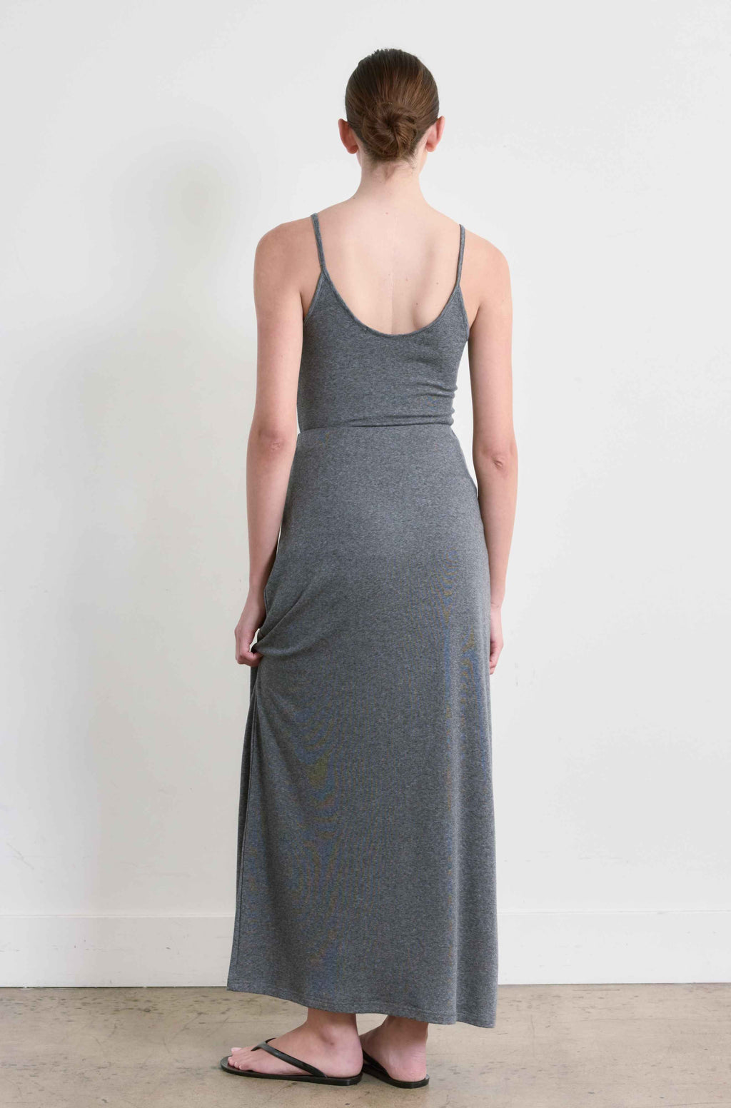 Woman wearing a gray dress standing against a white background