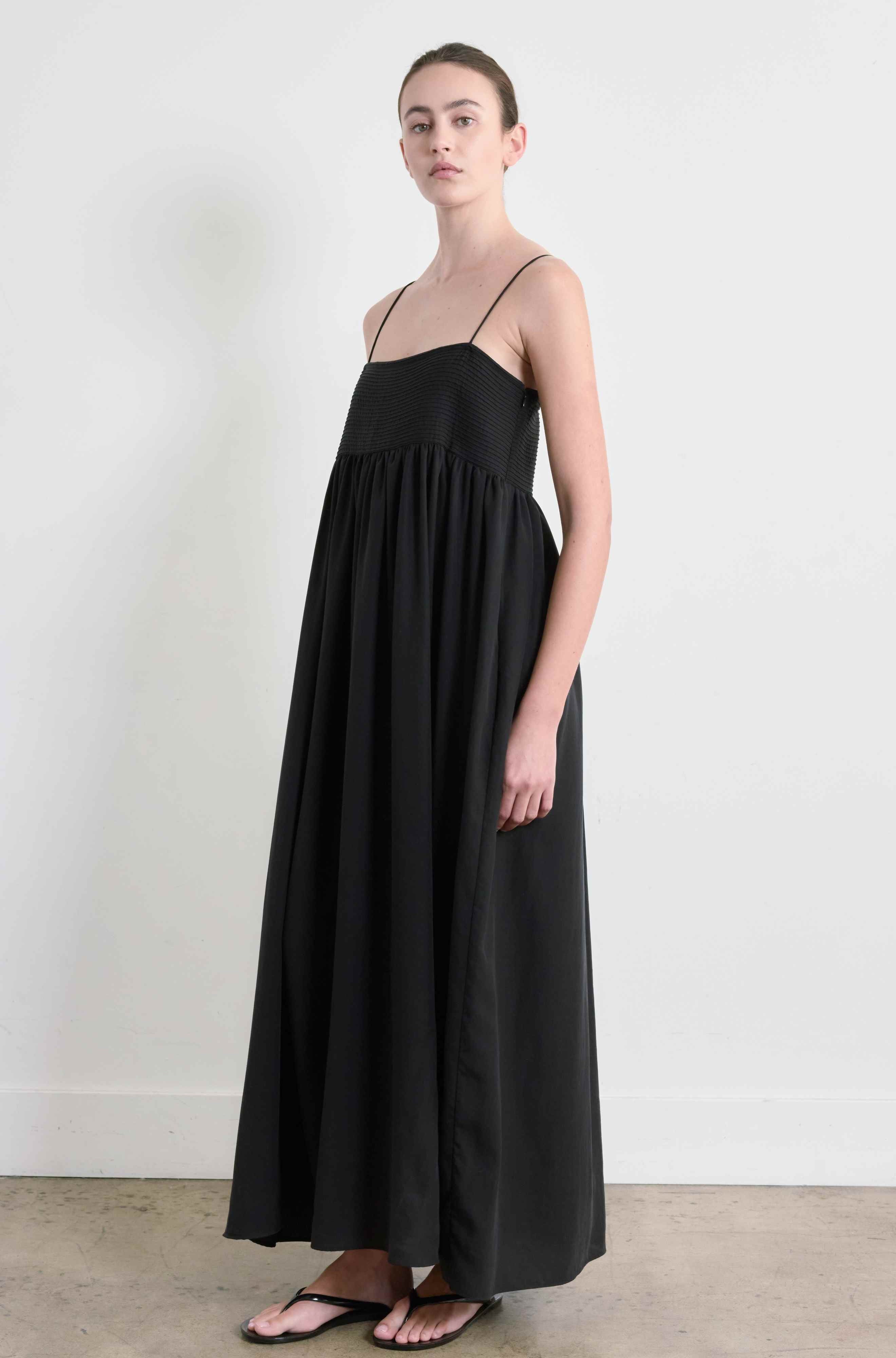 Woman wearing a black dress against a white background