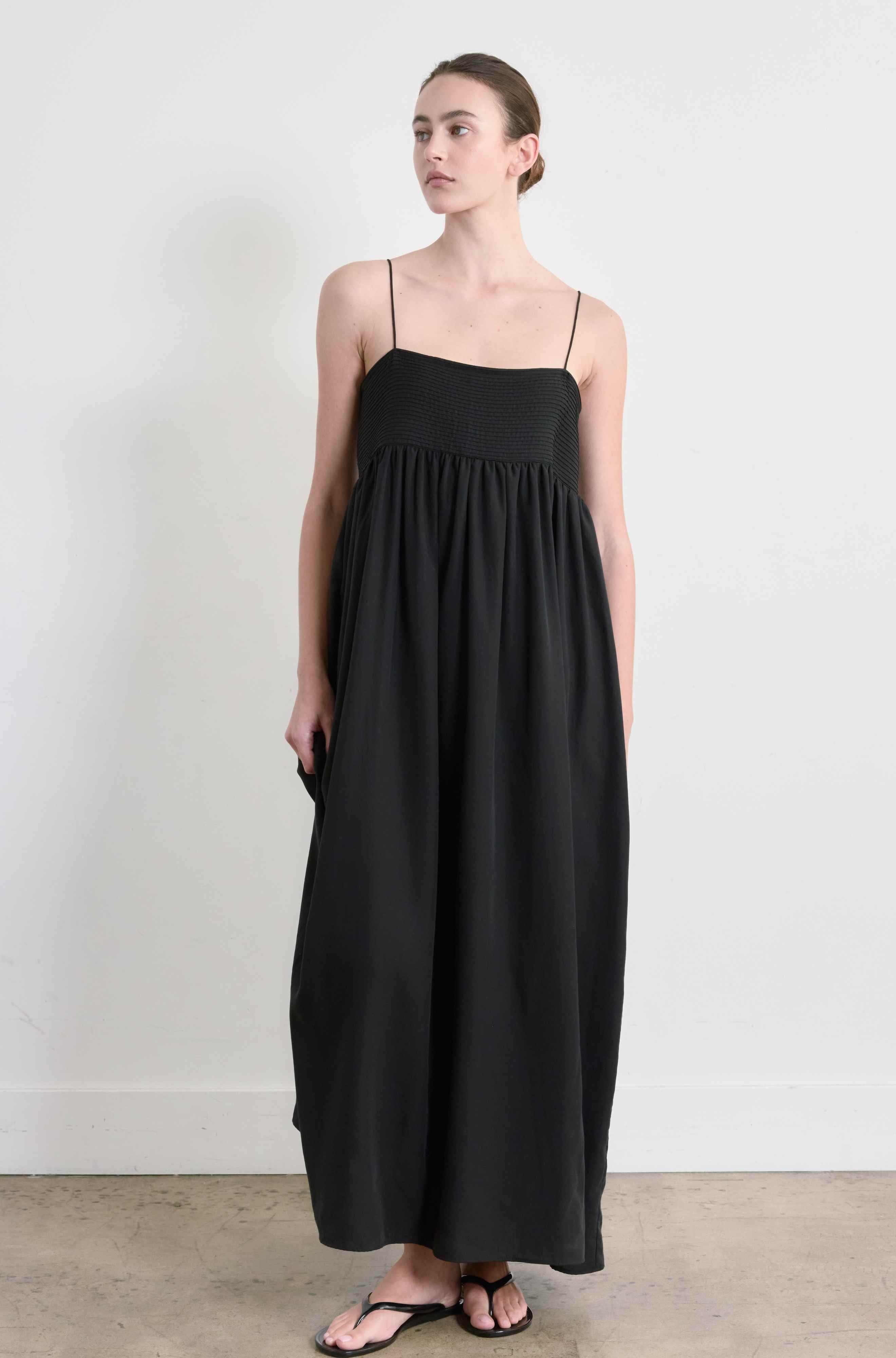 Woman wearing a black dress against a white background