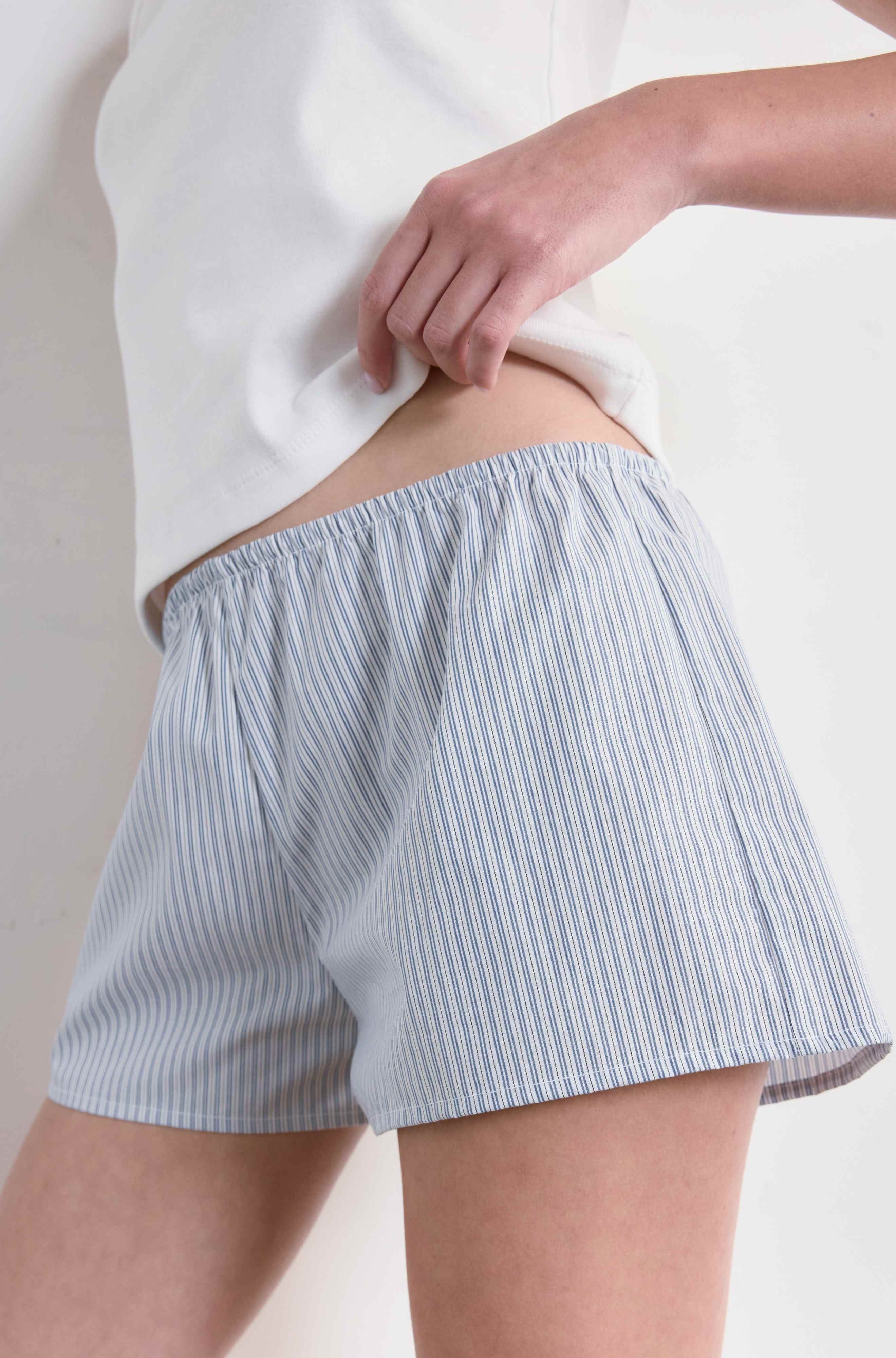 Light blue striped shorts worn by a person on a plain background