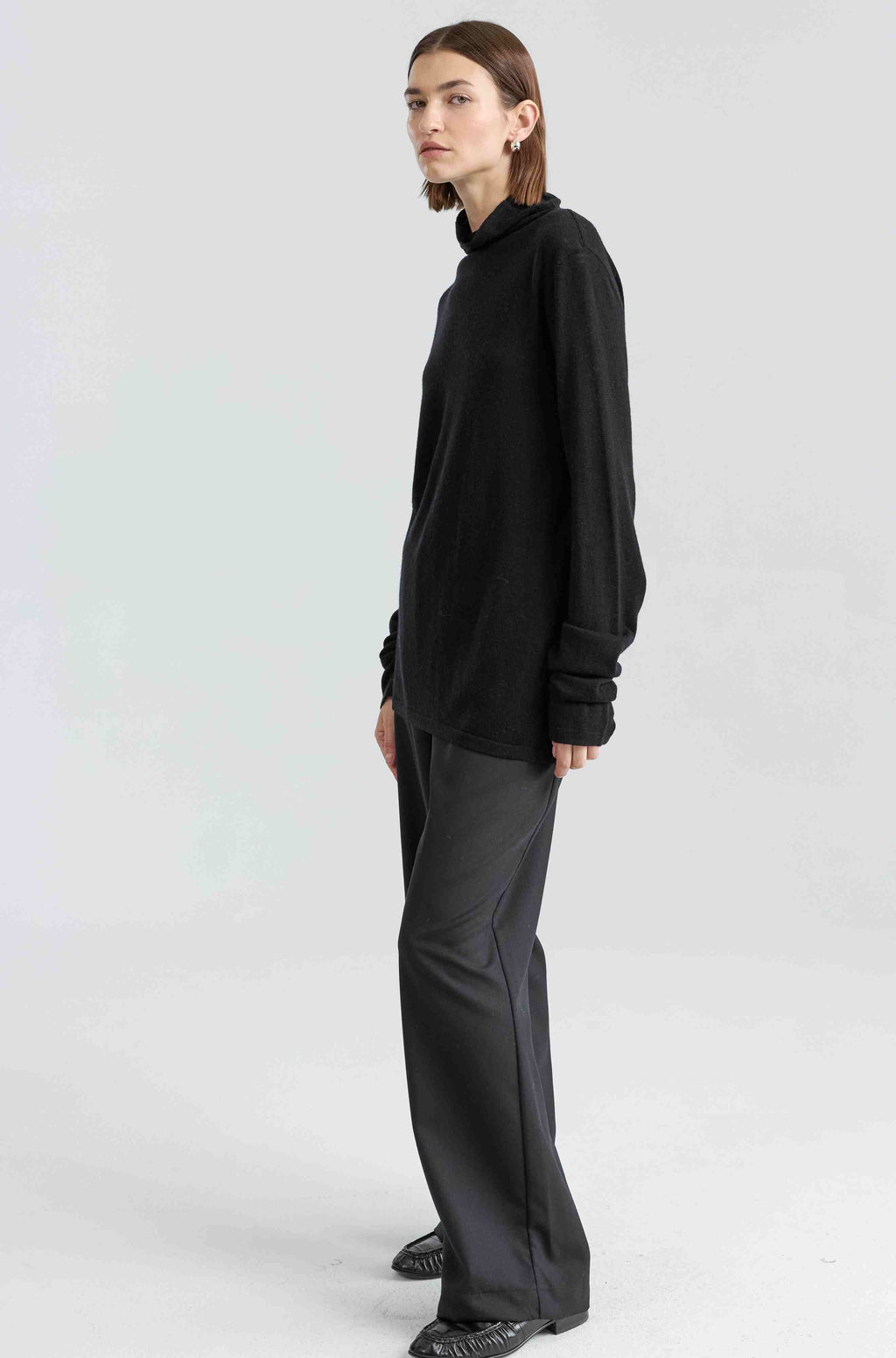 Person wearing a black outfit on a white background