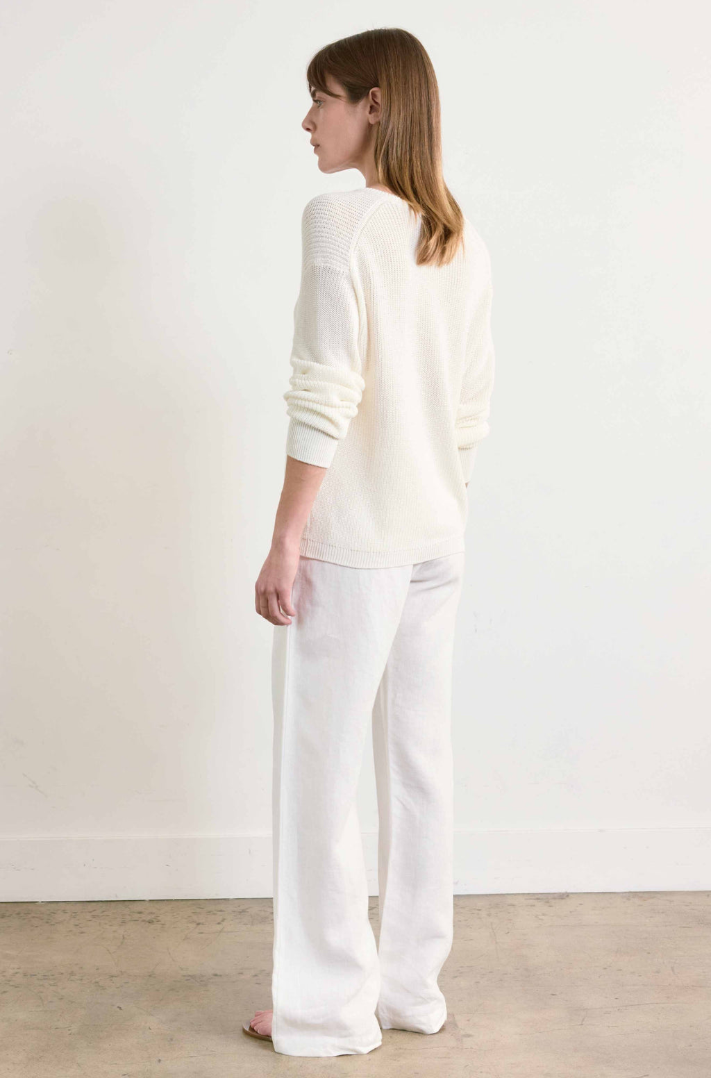 Woman wearing a white outfit against a plain background