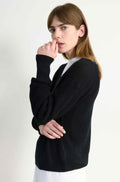 Woman wearing a black sweater on a white background
