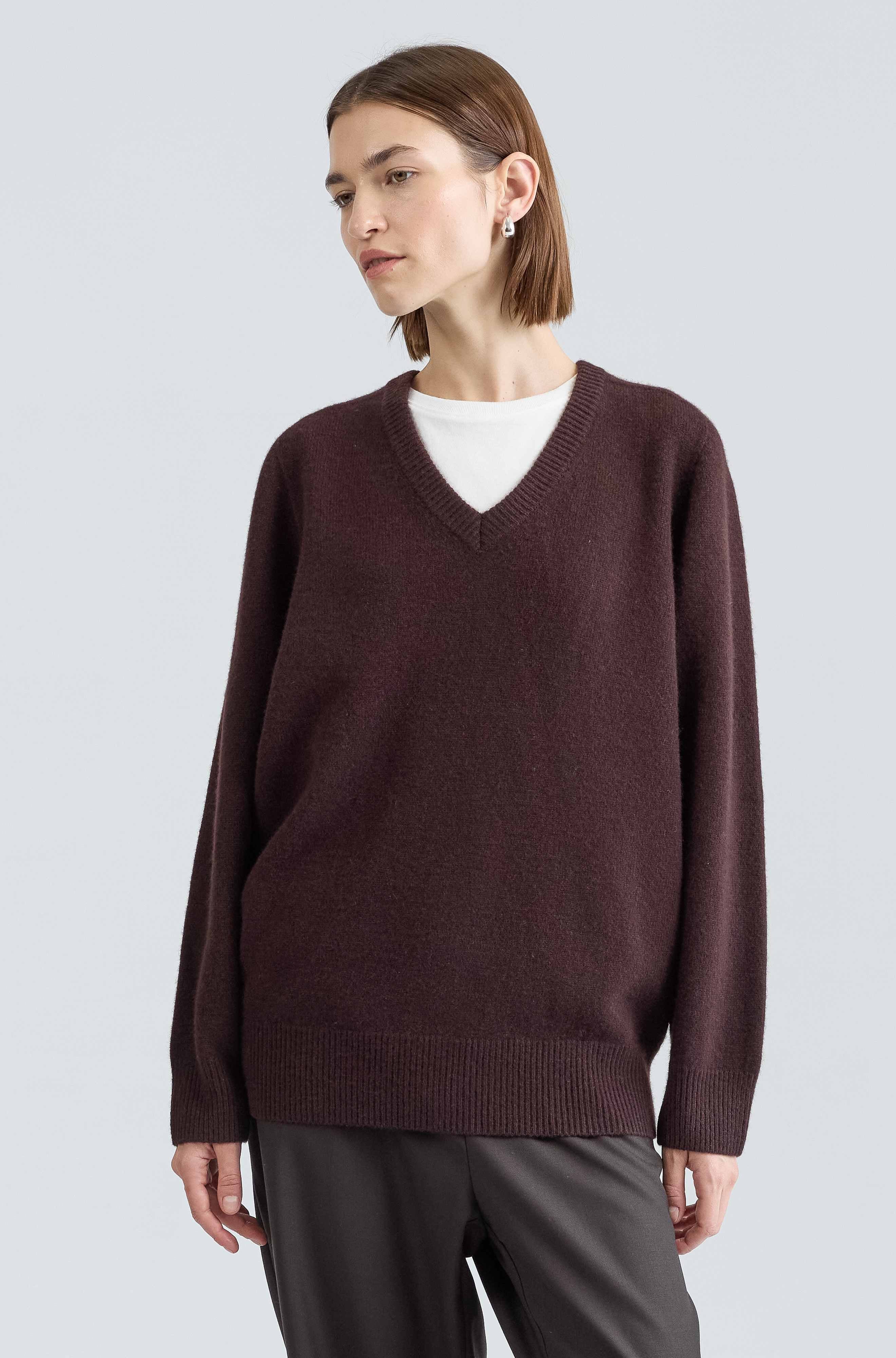 Woman wearing a brown sweater on a light gray background