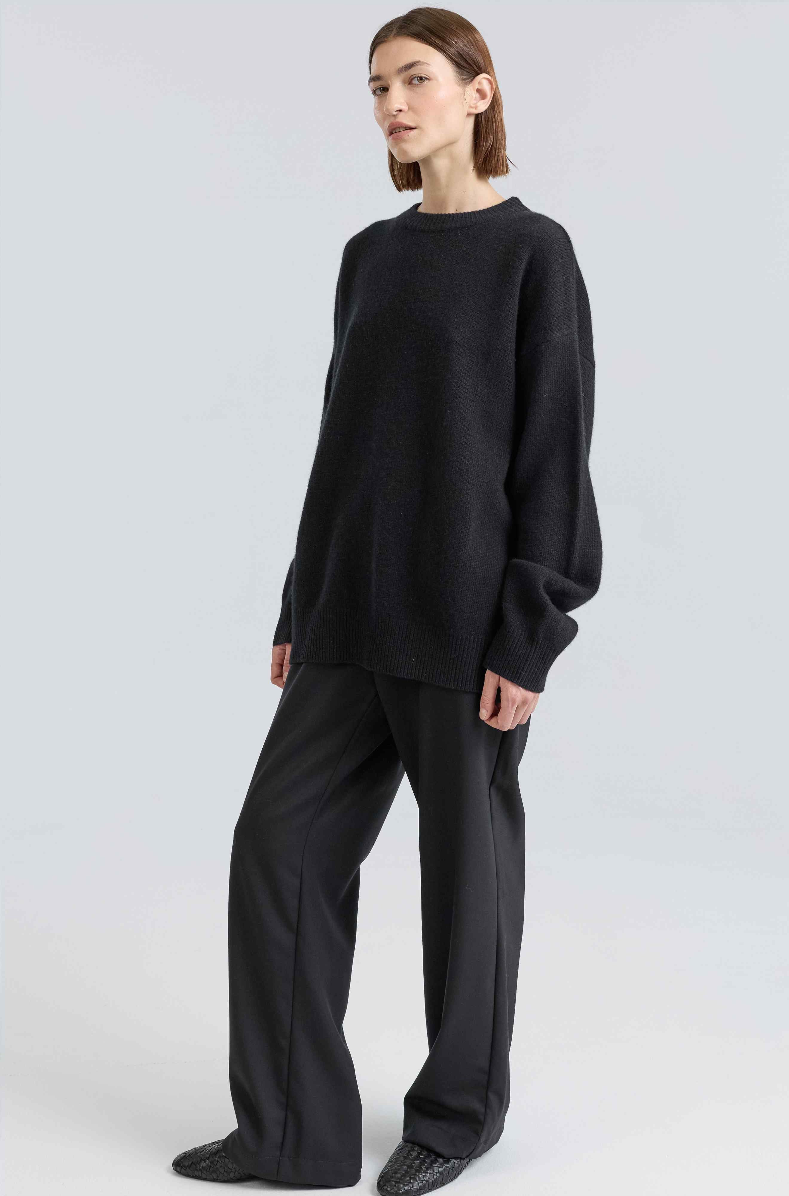 Person wearing a black outfit on a white background