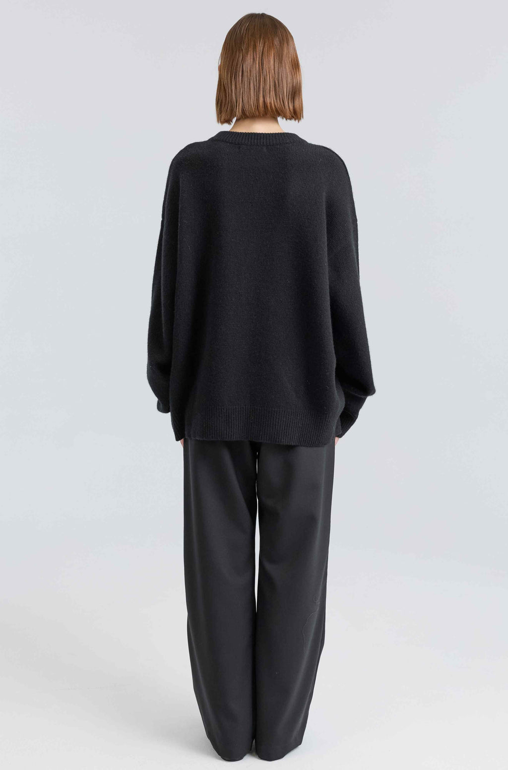 Person wearing a black outfit on a white background