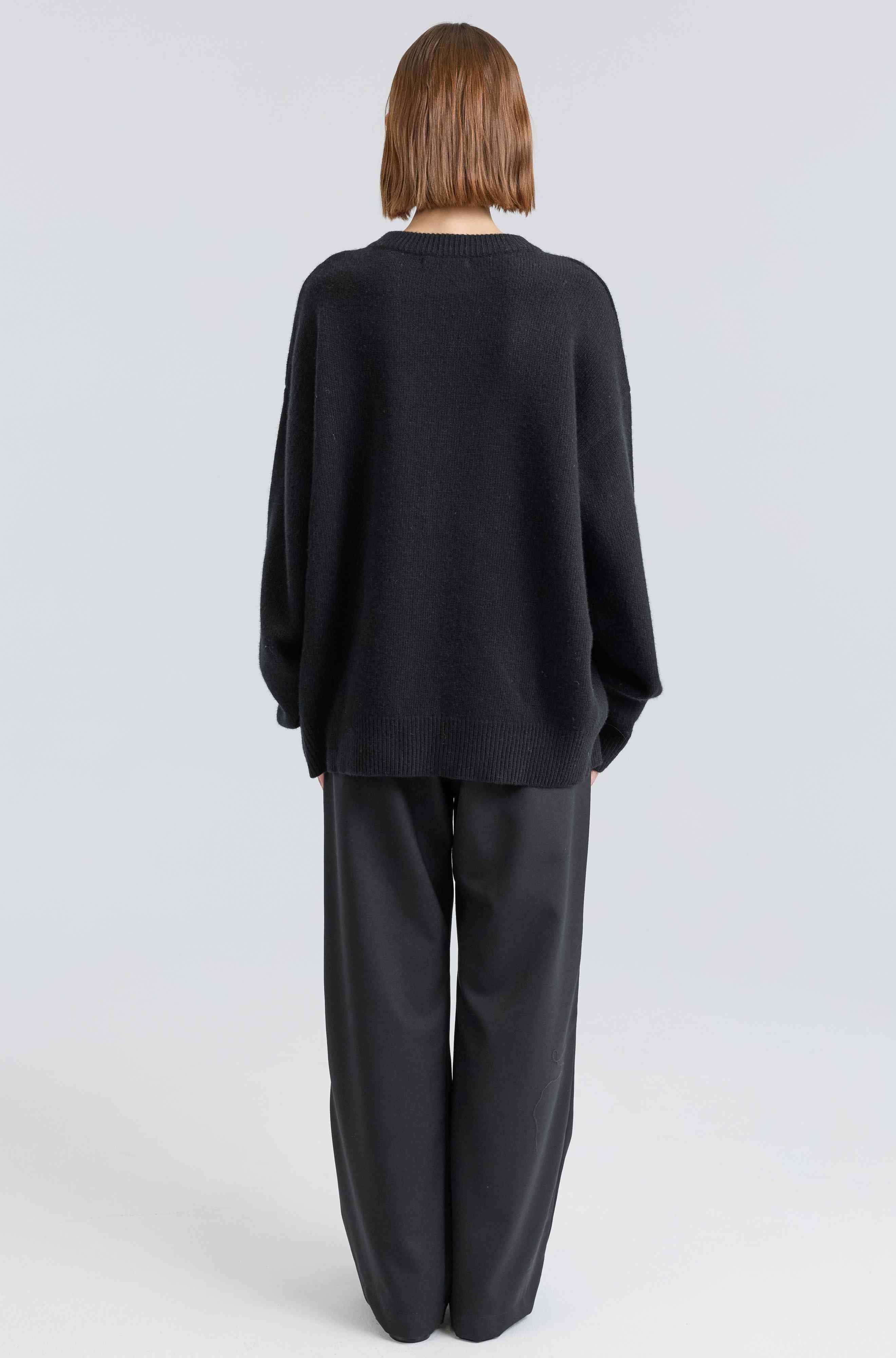 Person wearing a black outfit on a white background