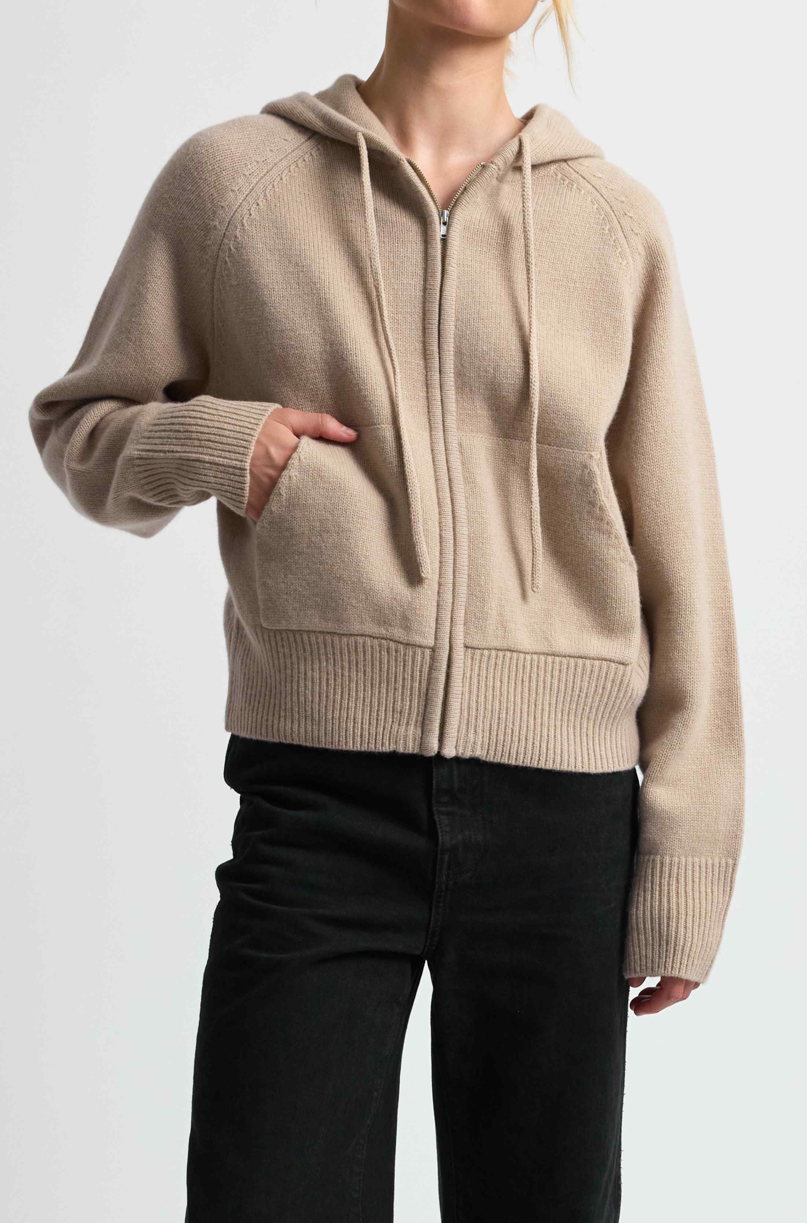 Beige zip-up hoodie worn by a person on a white background