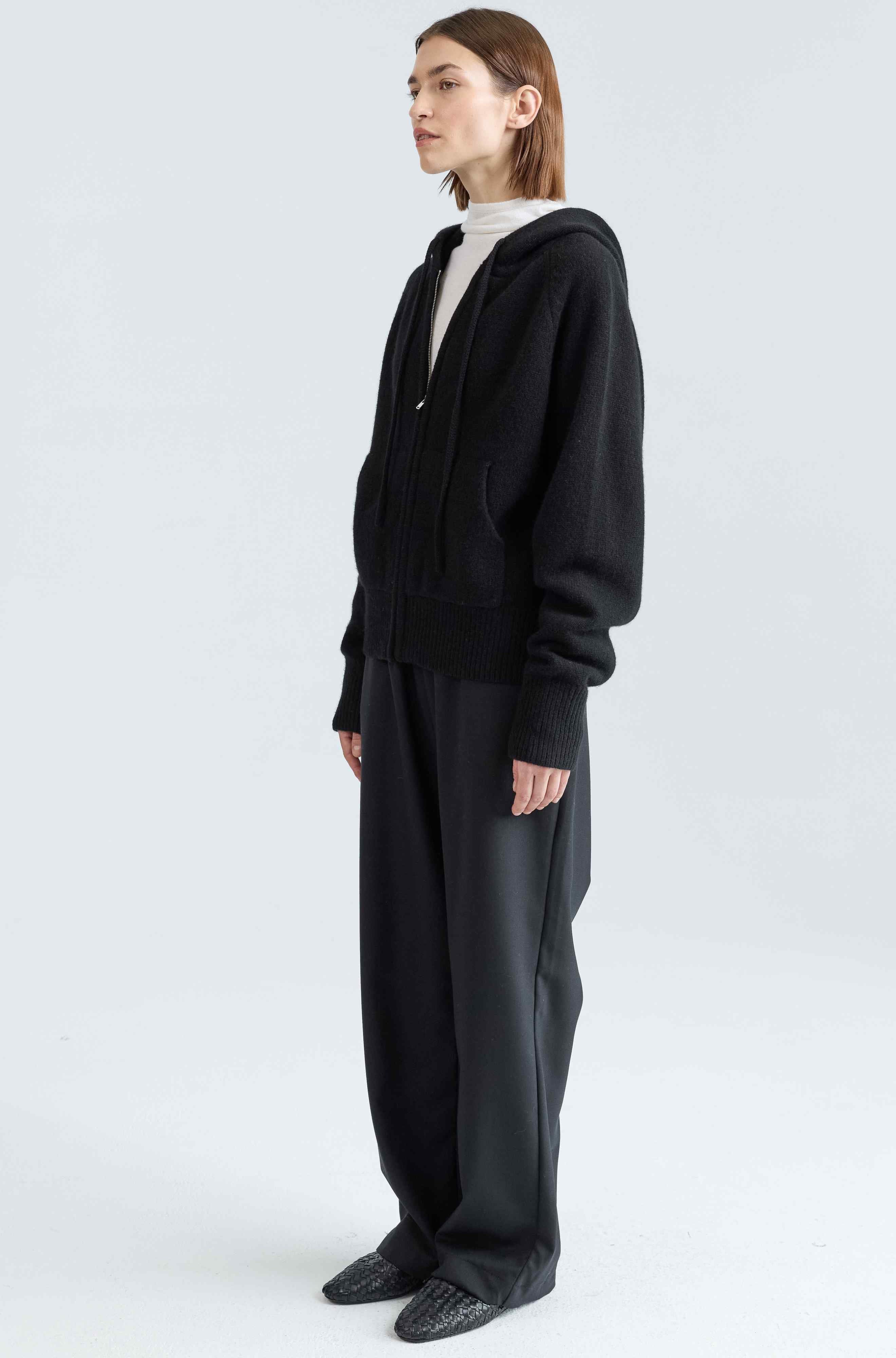 Person wearing a black hoodie on a white background